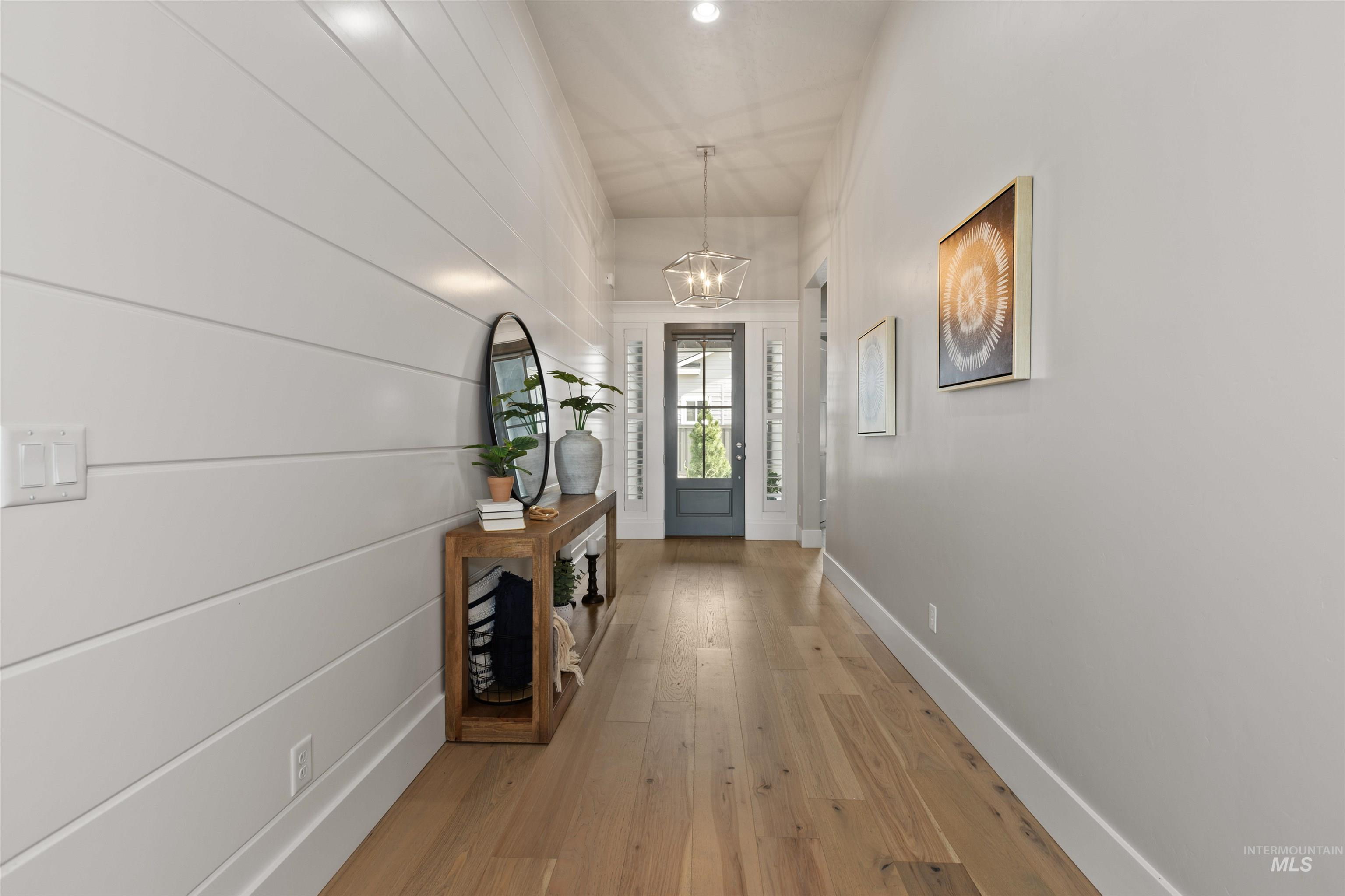 Doorway with hardwood / wood-style flooring and a chandelier