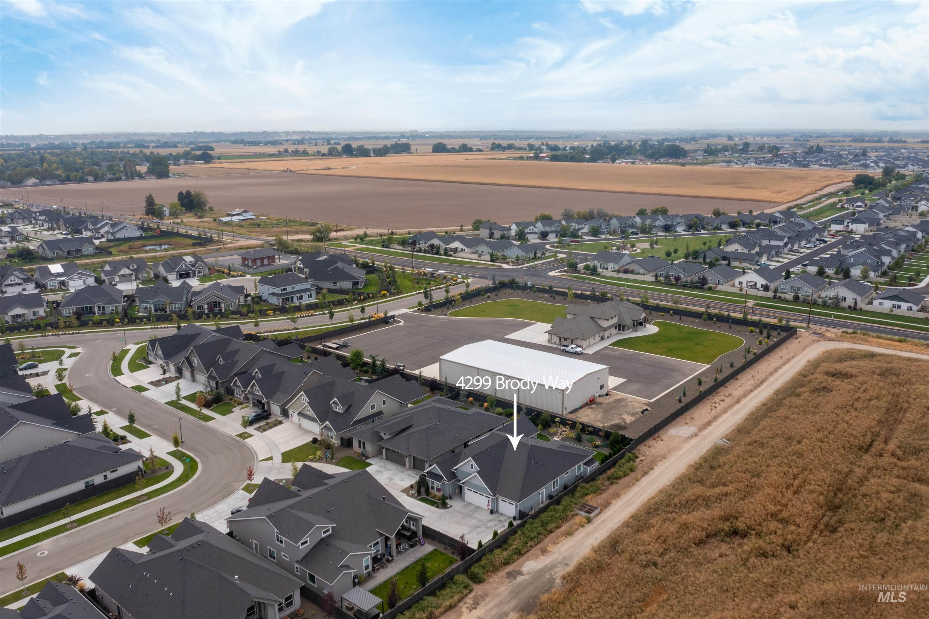 Aerial view of property and surrounding area featuring nearby suburban area