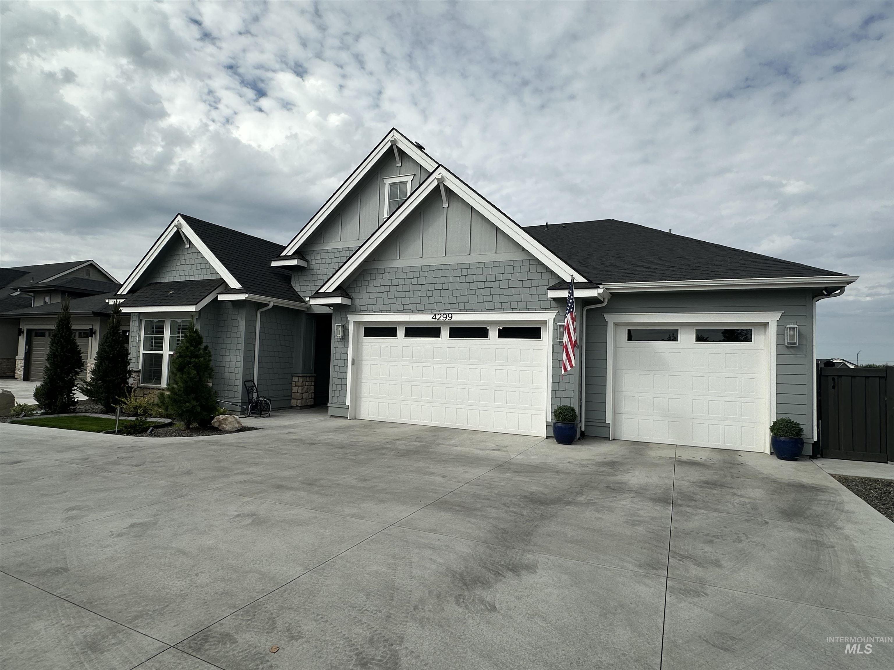 Craftsman house featuring concrete driveway, an attached garage, board and batten siding, and roof with shingles