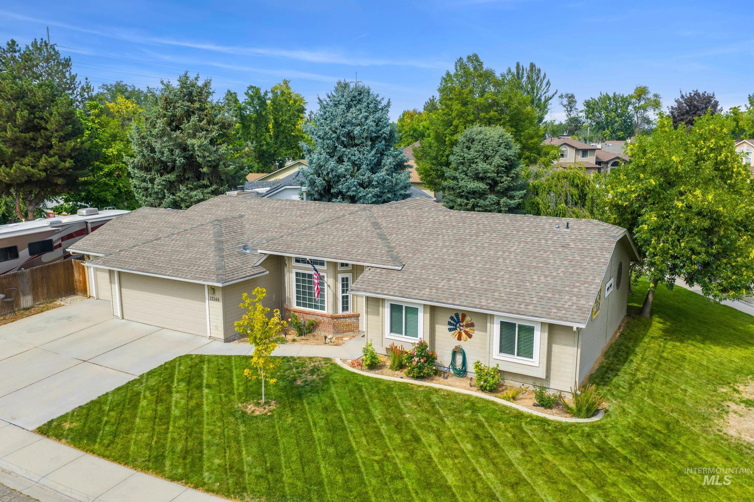 View of front of home with roof with shingles, concrete driveway, and a garage
