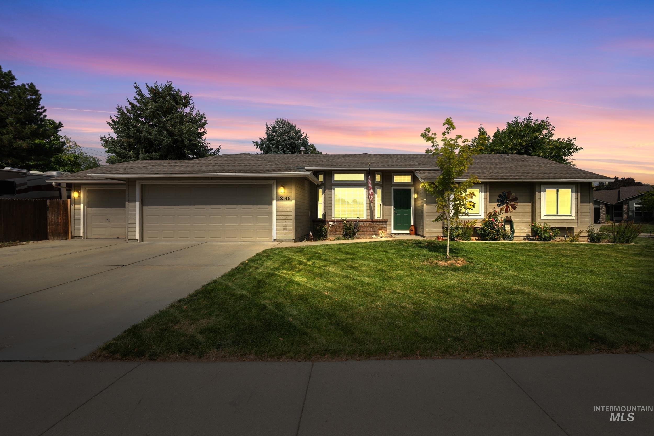 View of front of home featuring concrete driveway, an attached garage, a yard, and a shingled roof