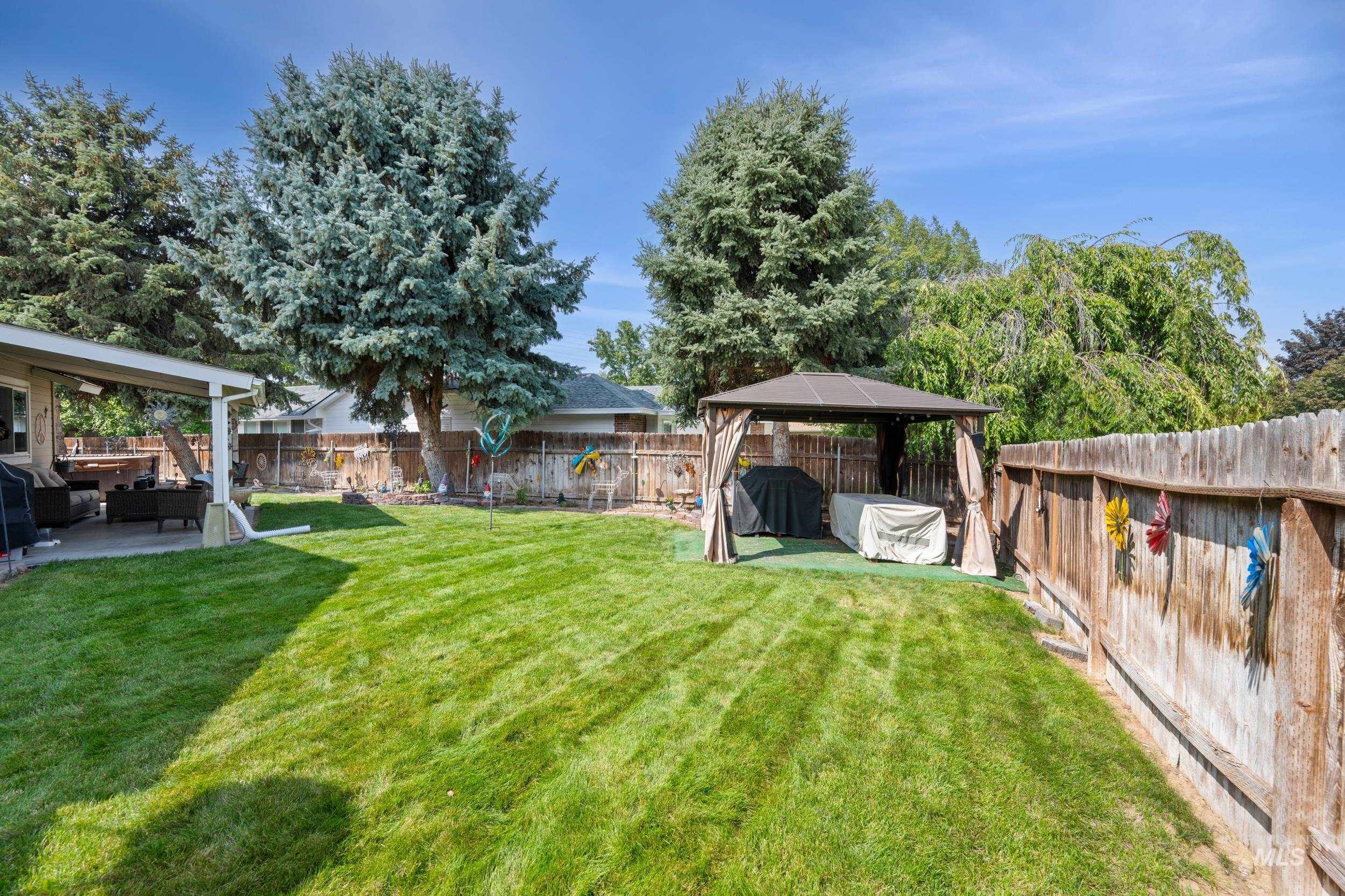 Fenced backyard featuring a patio, a gazebo, and an outdoor hangout area