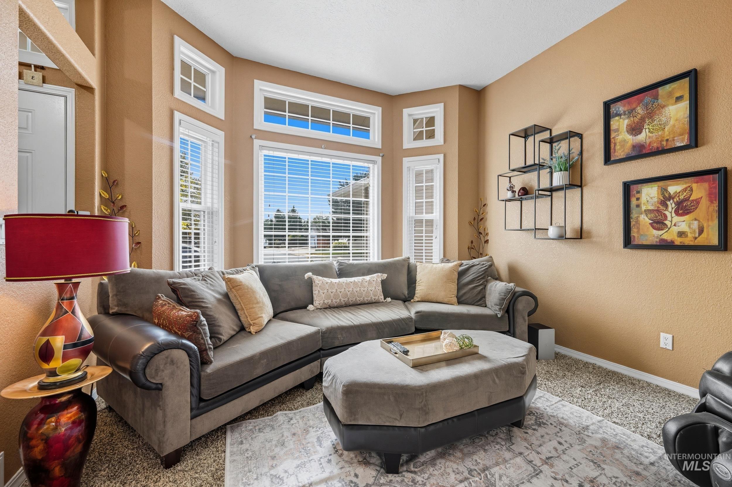 Carpeted living room with a textured wall