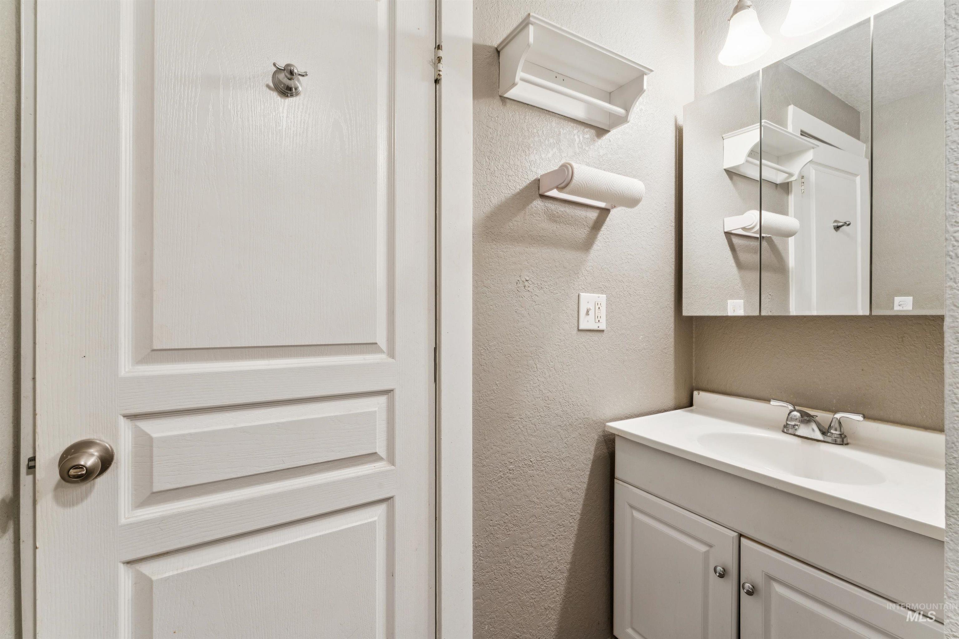 Bathroom with vanity and a textured wall