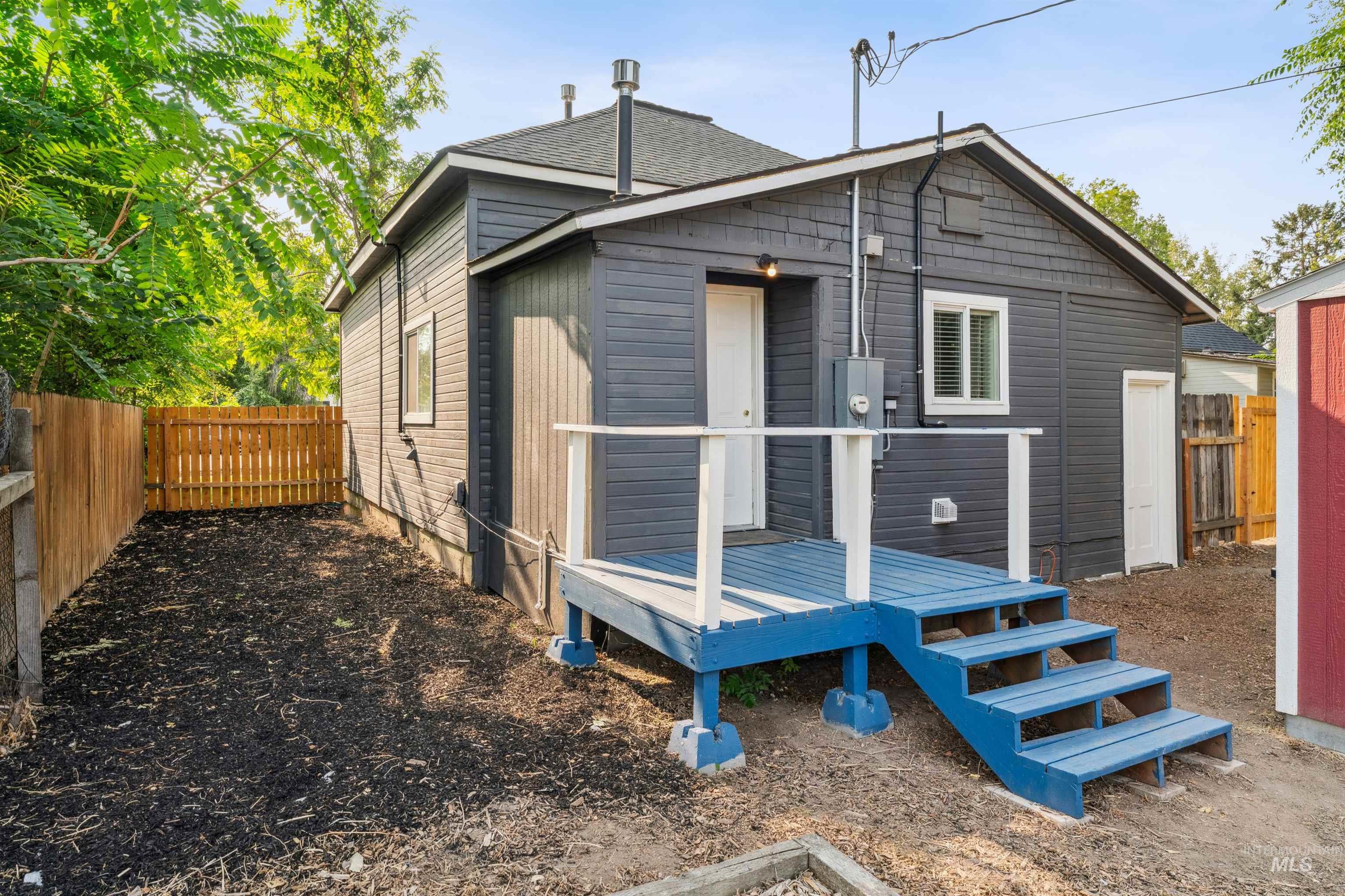 Back of property featuring a fenced backyard and a wooden deck