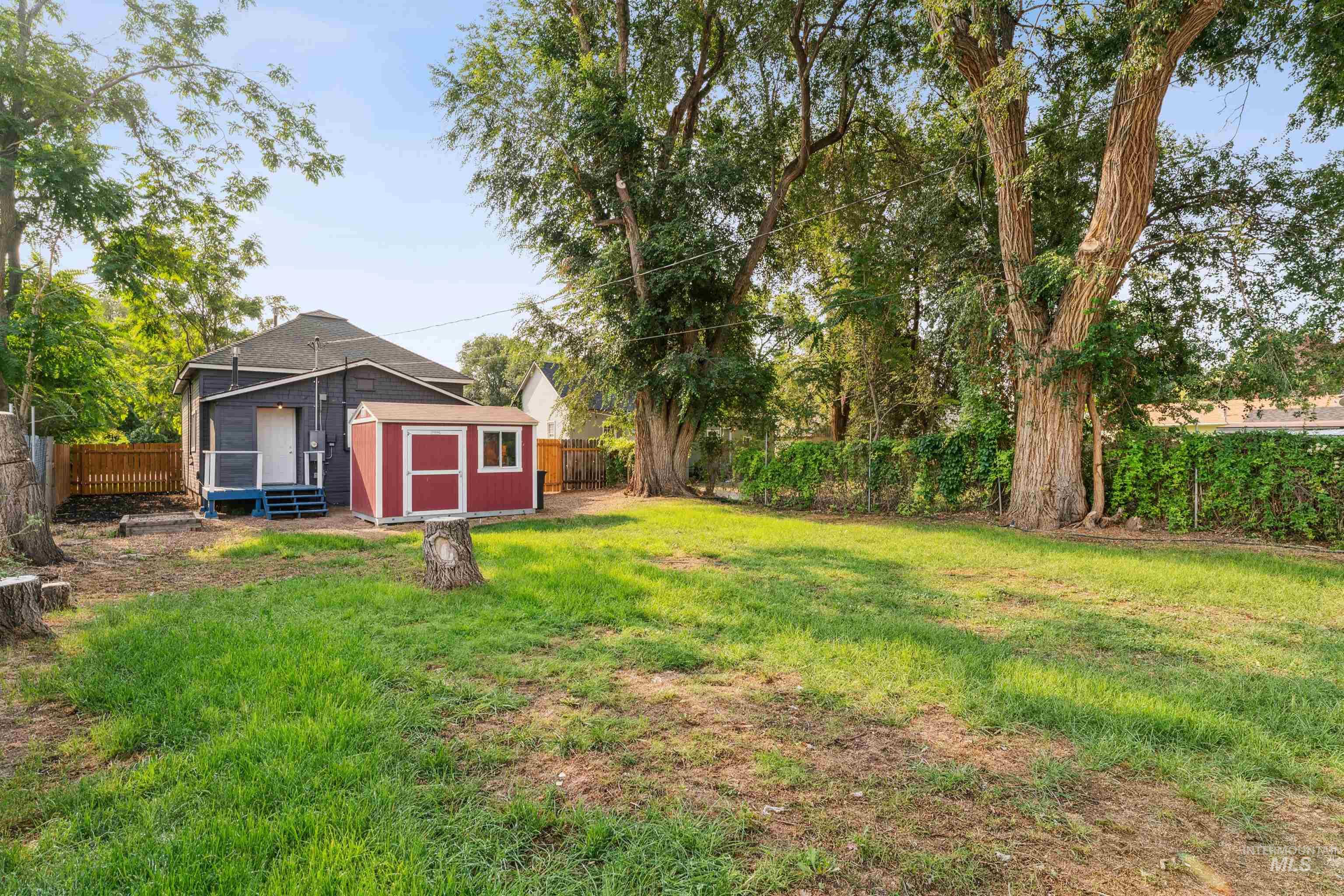 Fenced backyard featuring a shed and a sunroom