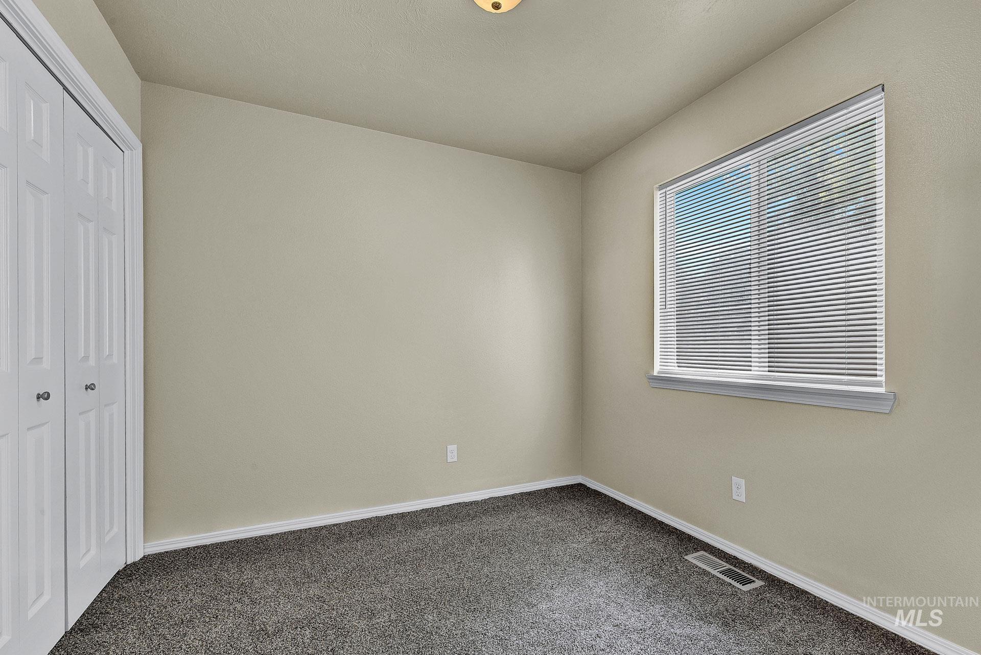 Unfurnished bedroom with a closet and dark carpet