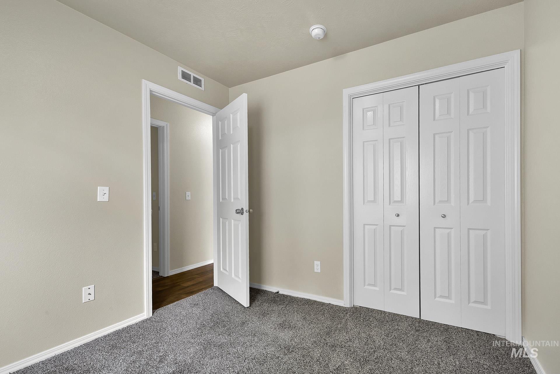 Unfurnished bedroom with dark colored carpet and a closet