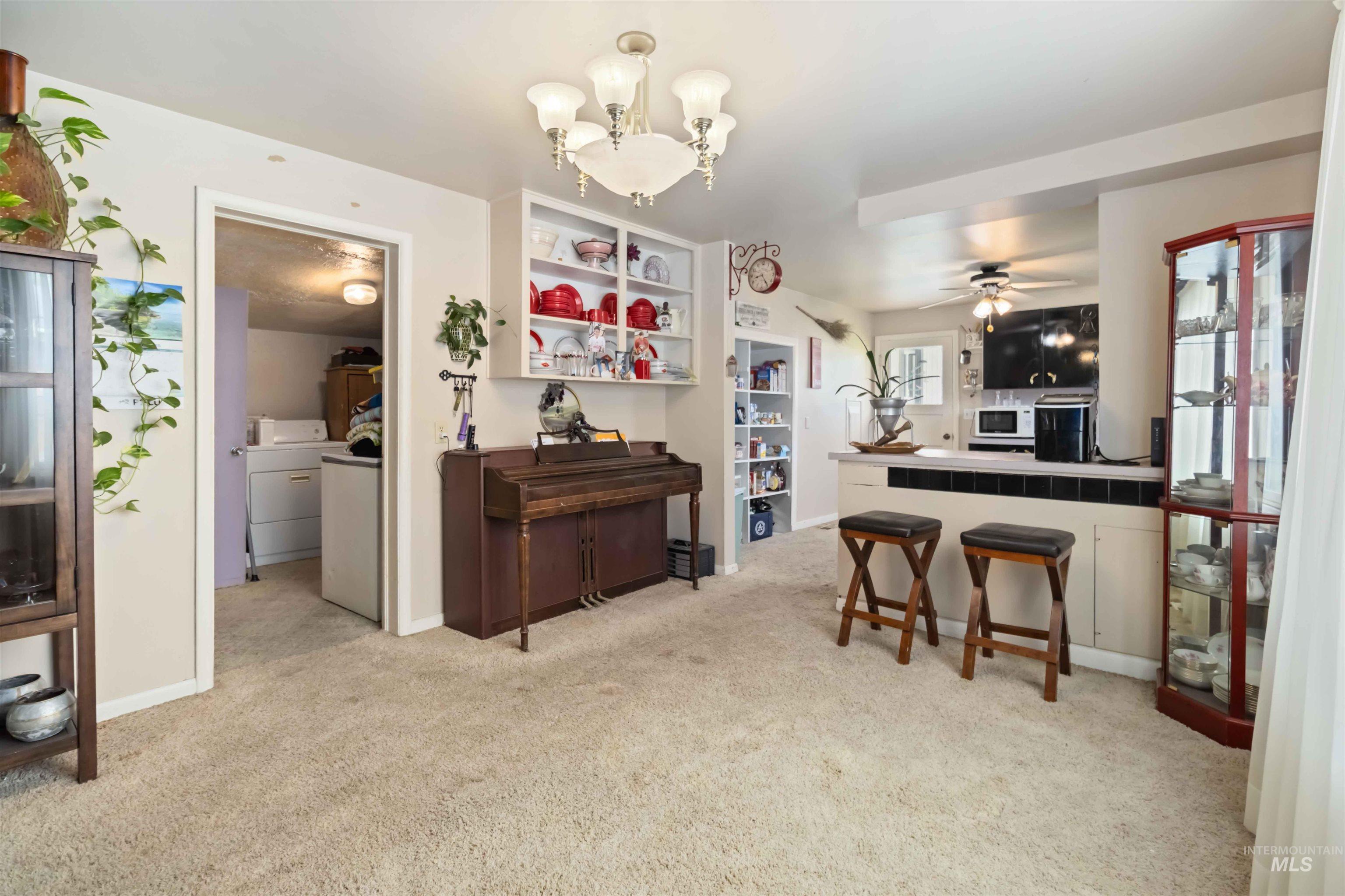 Kitchen with a chandelier, light carpet, a peninsula, and washer / dryer