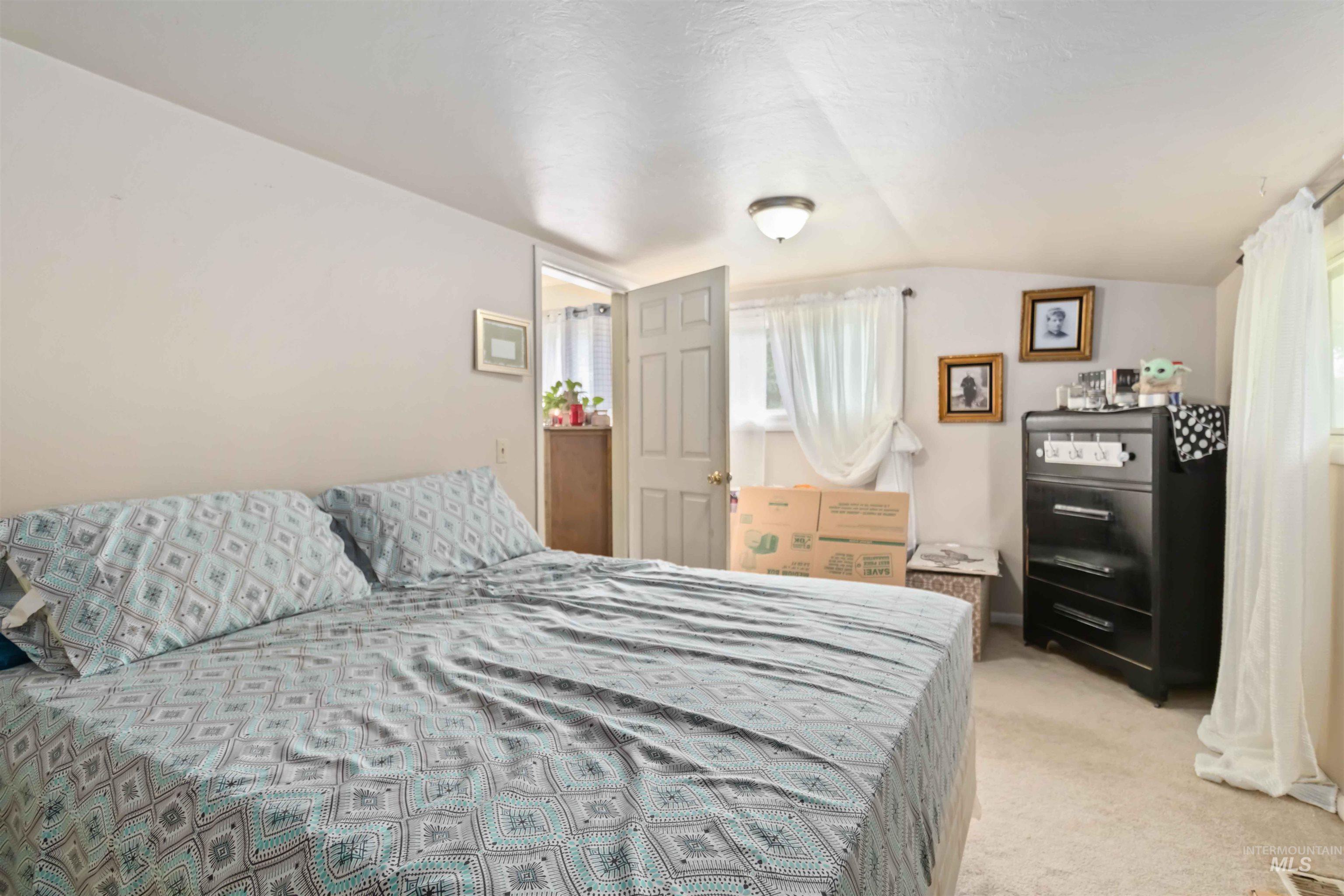 Bedroom featuring carpet and lofted ceiling