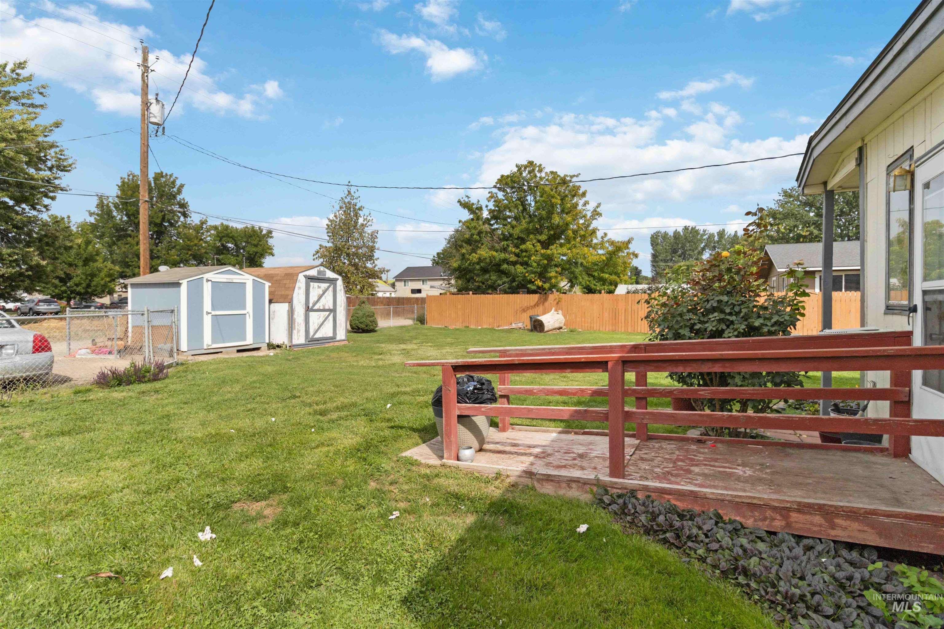 Fenced backyard featuring a storage unit