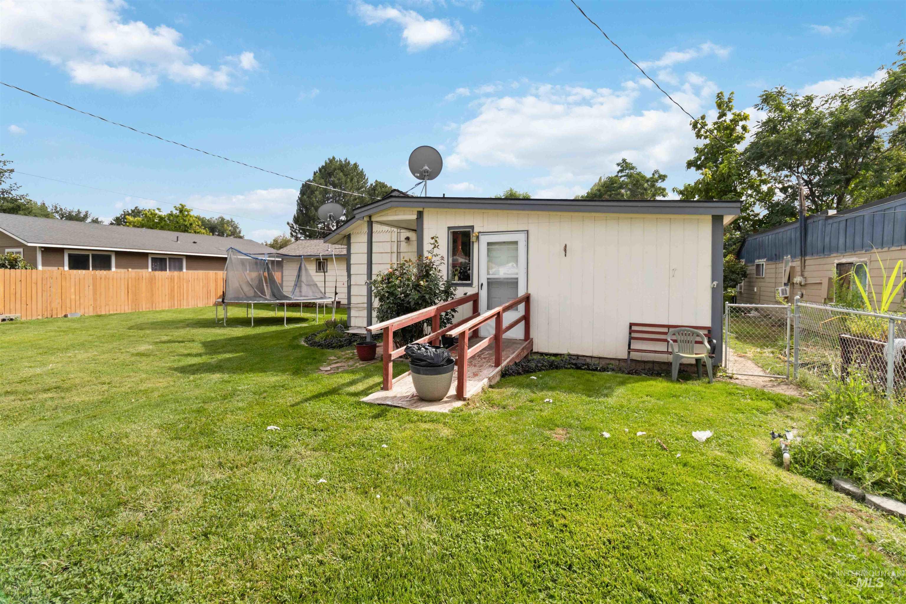 Back of property featuring a fenced backyard and a trampoline