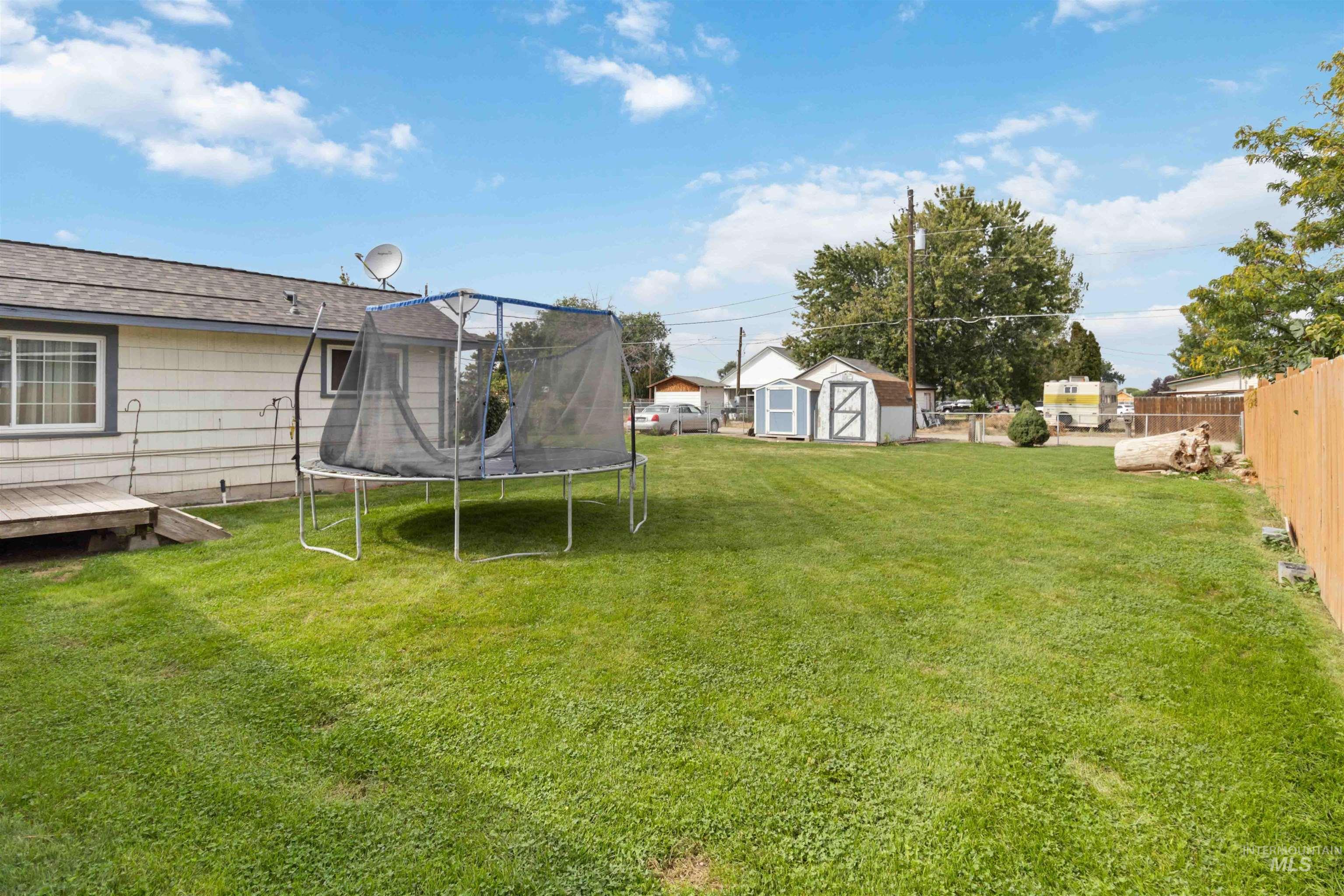 View of yard with a trampoline and a shed