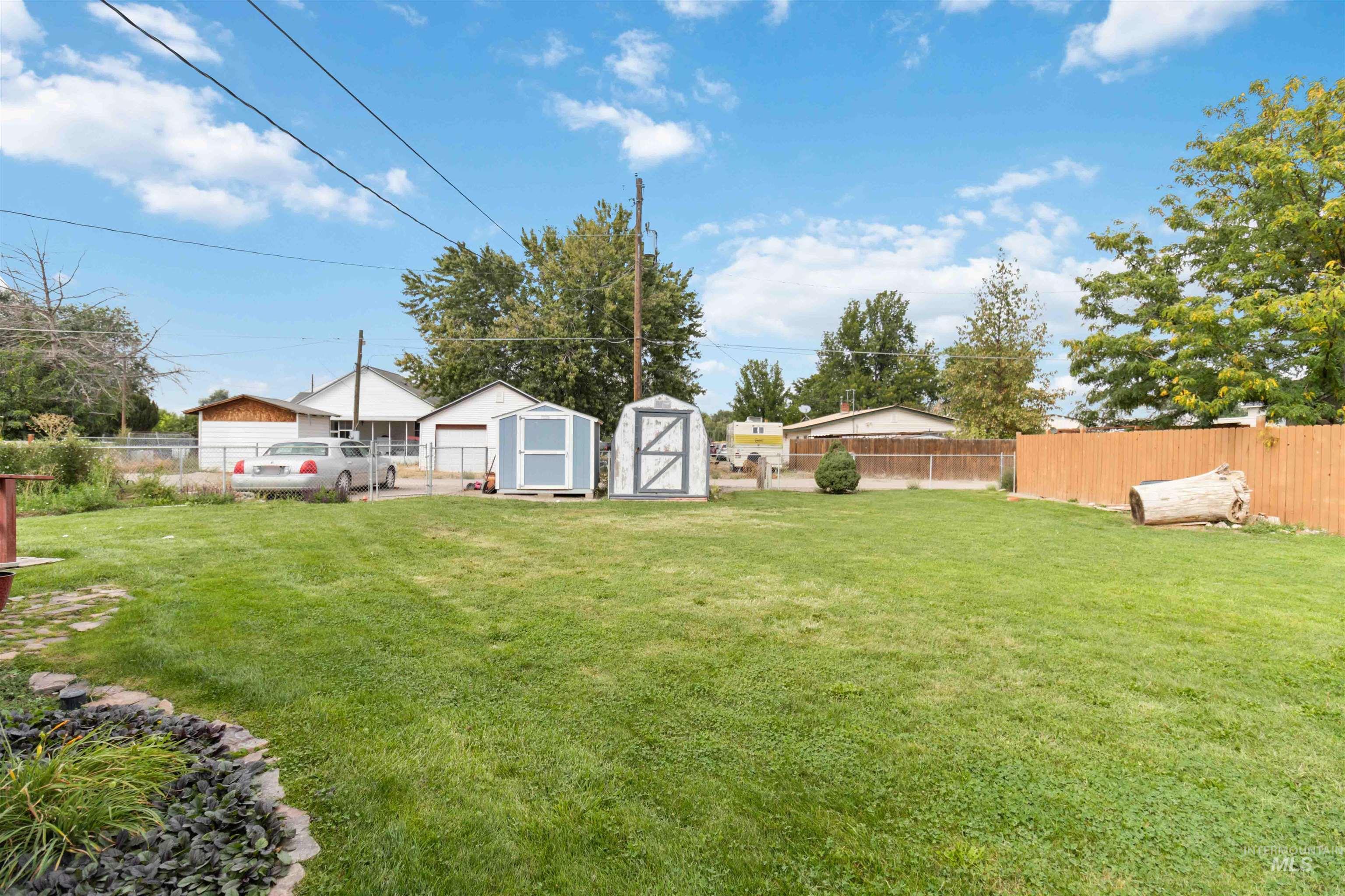 Fenced backyard featuring a shed