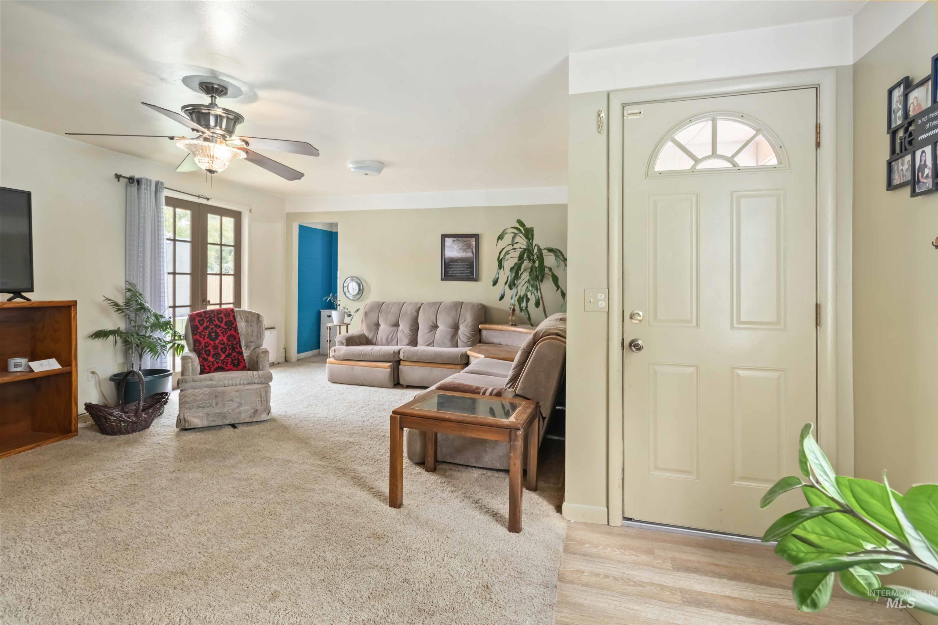 Living room featuring a ceiling fan and light colored carpet