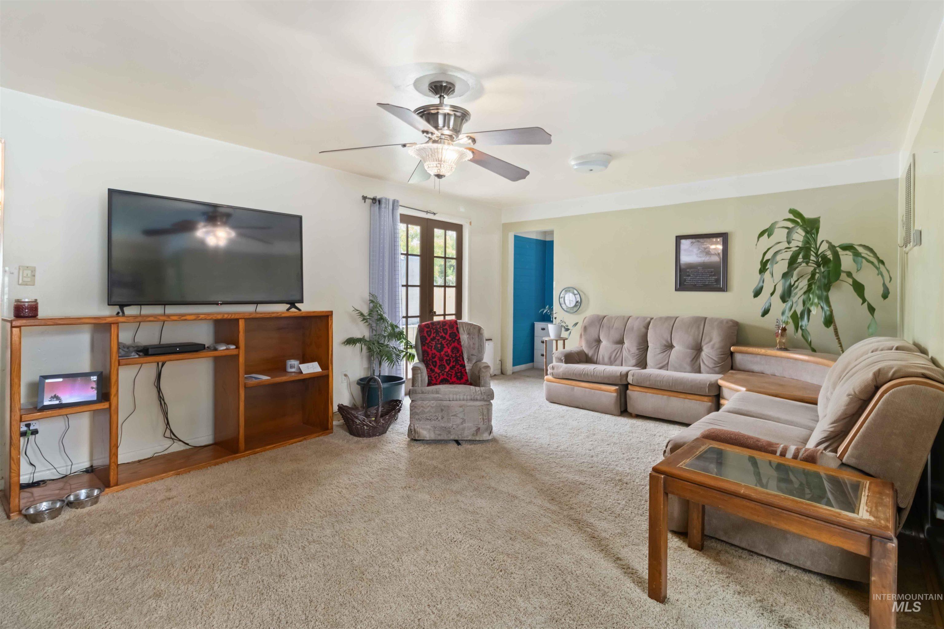 Carpeted living area with ceiling fan
