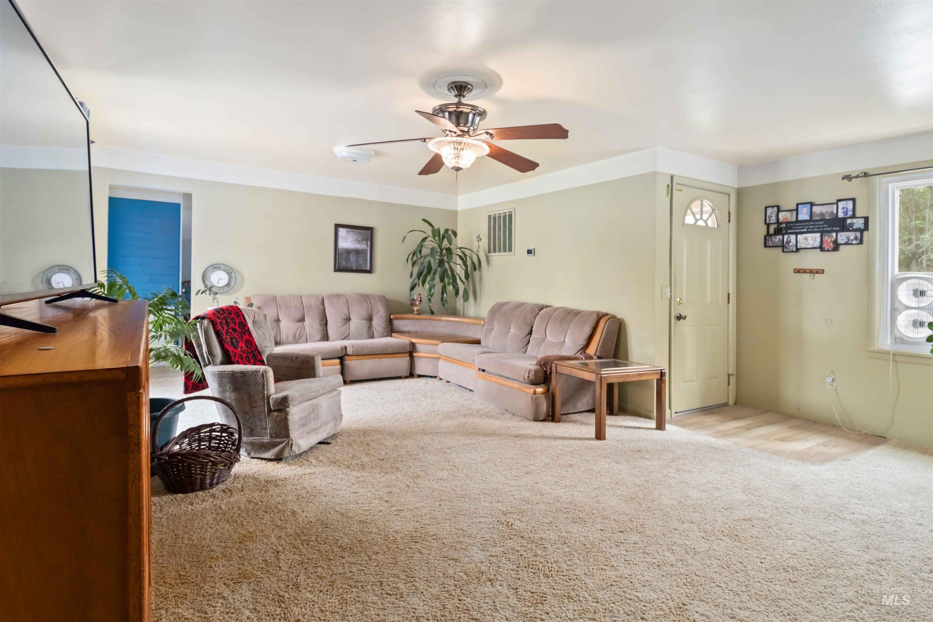 Living area featuring carpet flooring and ceiling fan