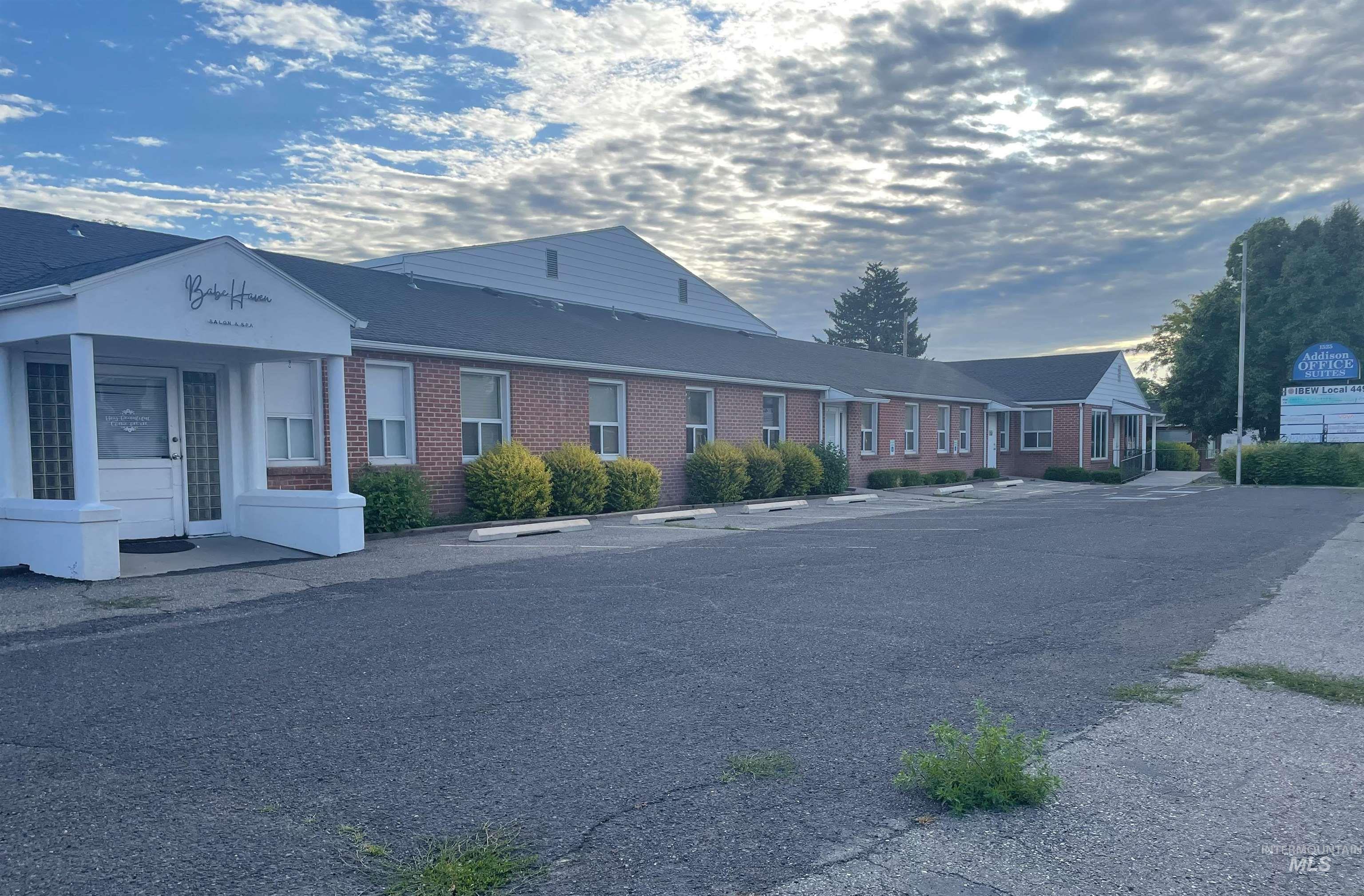 View of building exterior with uncovered parking