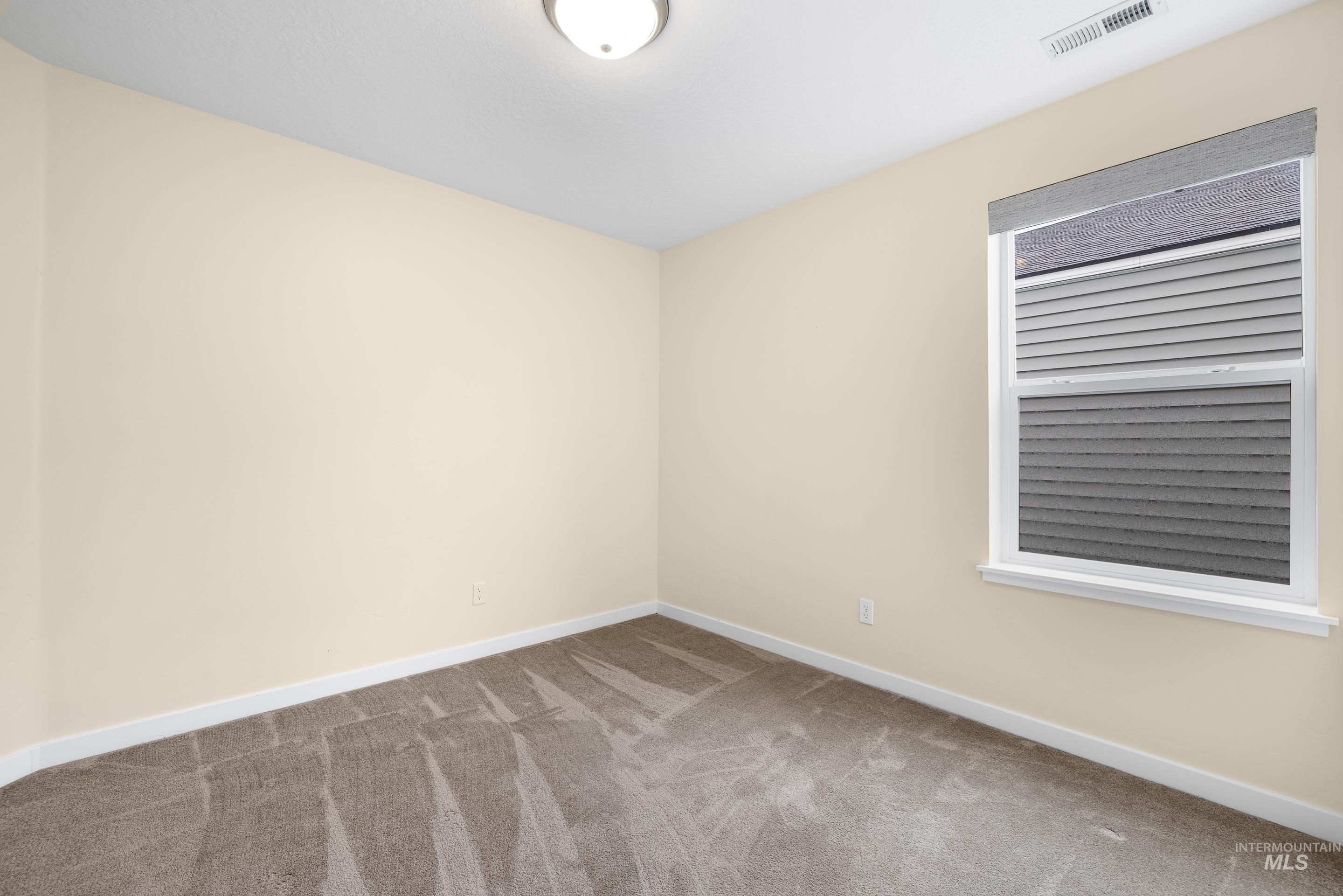 Spare room featuring carpet and baseboards