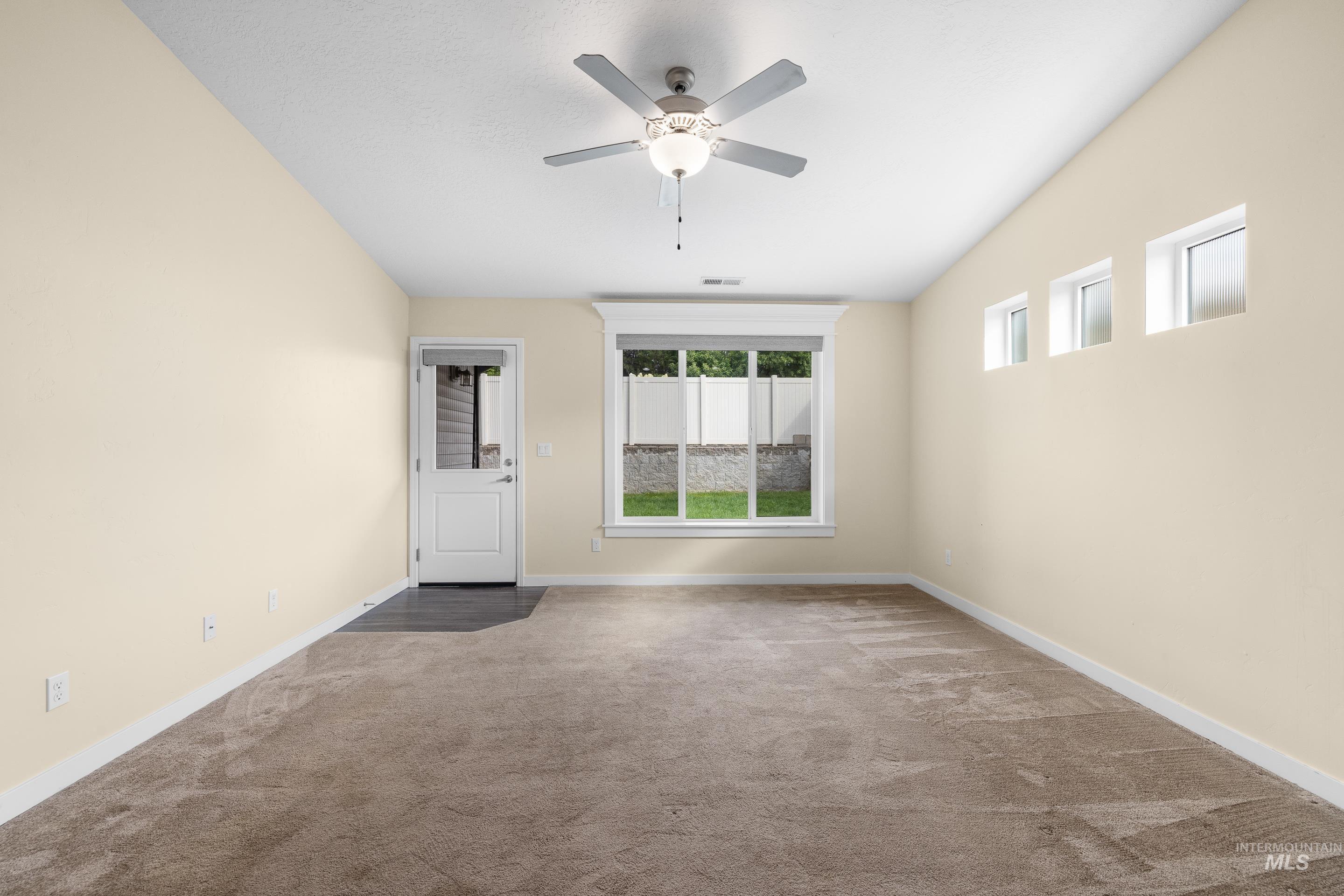Empty room featuring carpet floors and ceiling fan