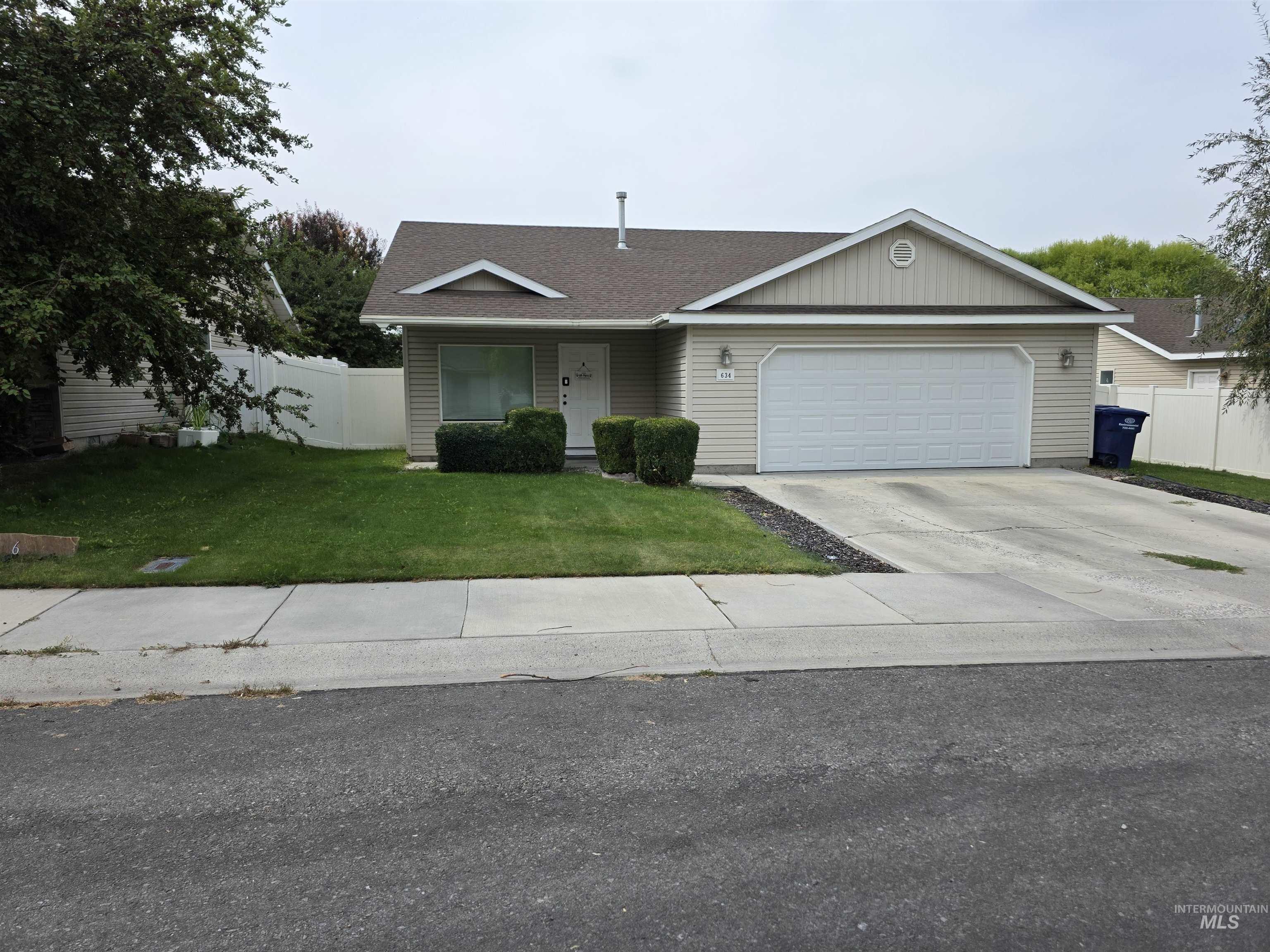 Single story home featuring a porch, concrete driveway, roof with shingles, and a garage