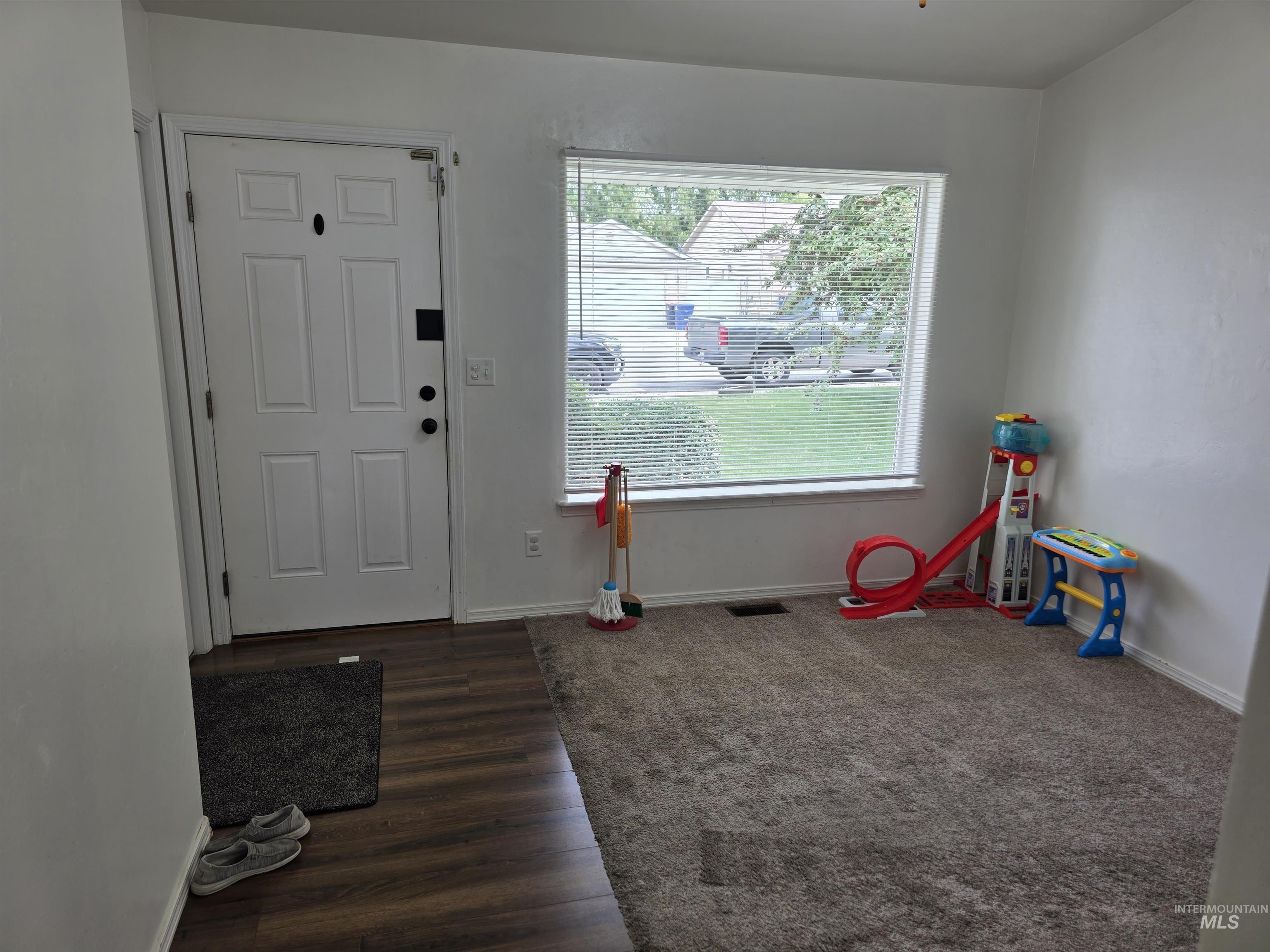 Entrance foyer with baseboards and dark wood-type flooring