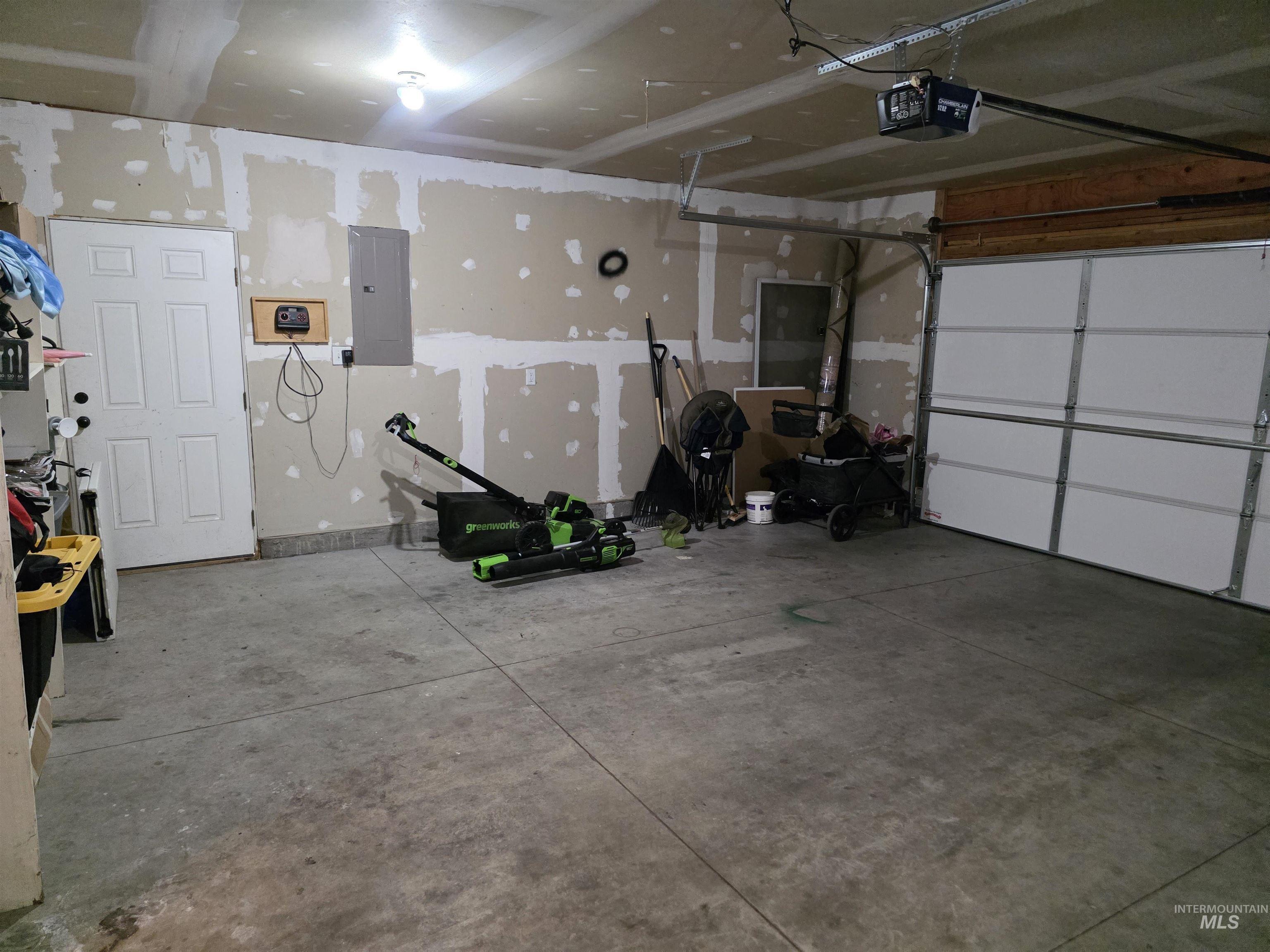 Garage featuring electric panel and a garage door opener