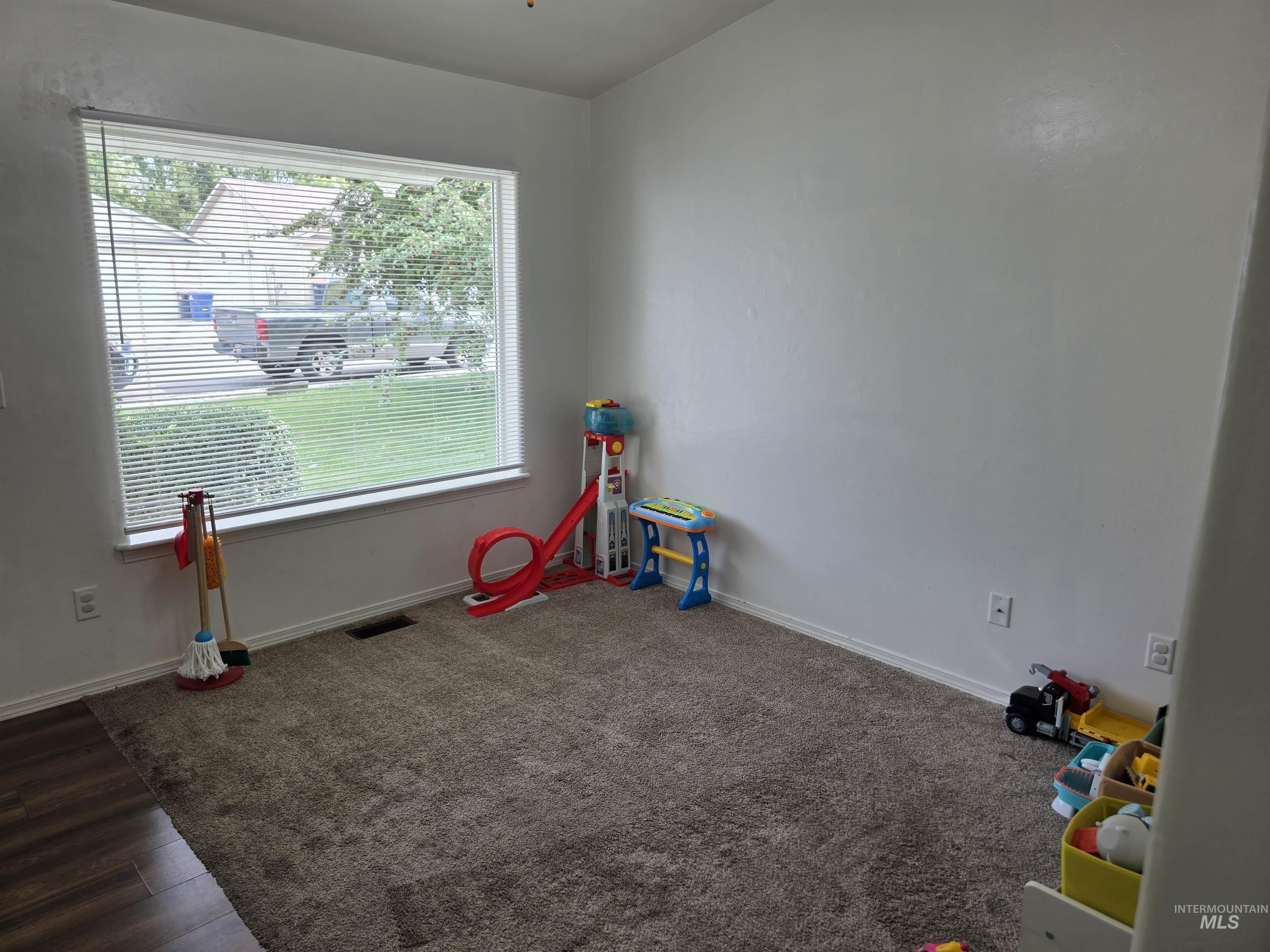 Playroom featuring baseboards and dark wood-style floors