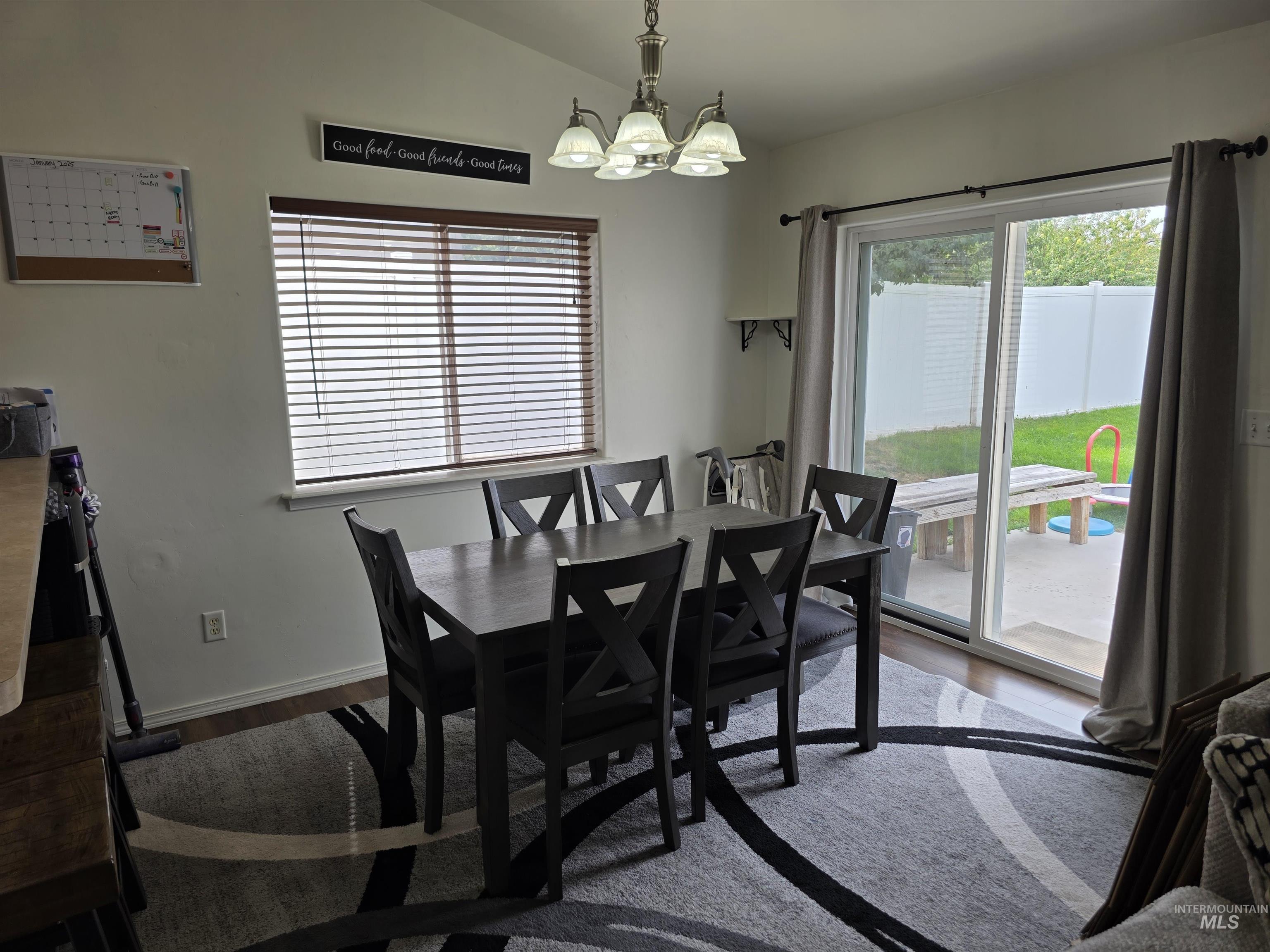 Dining area with dark wood-type flooring and a chandelier