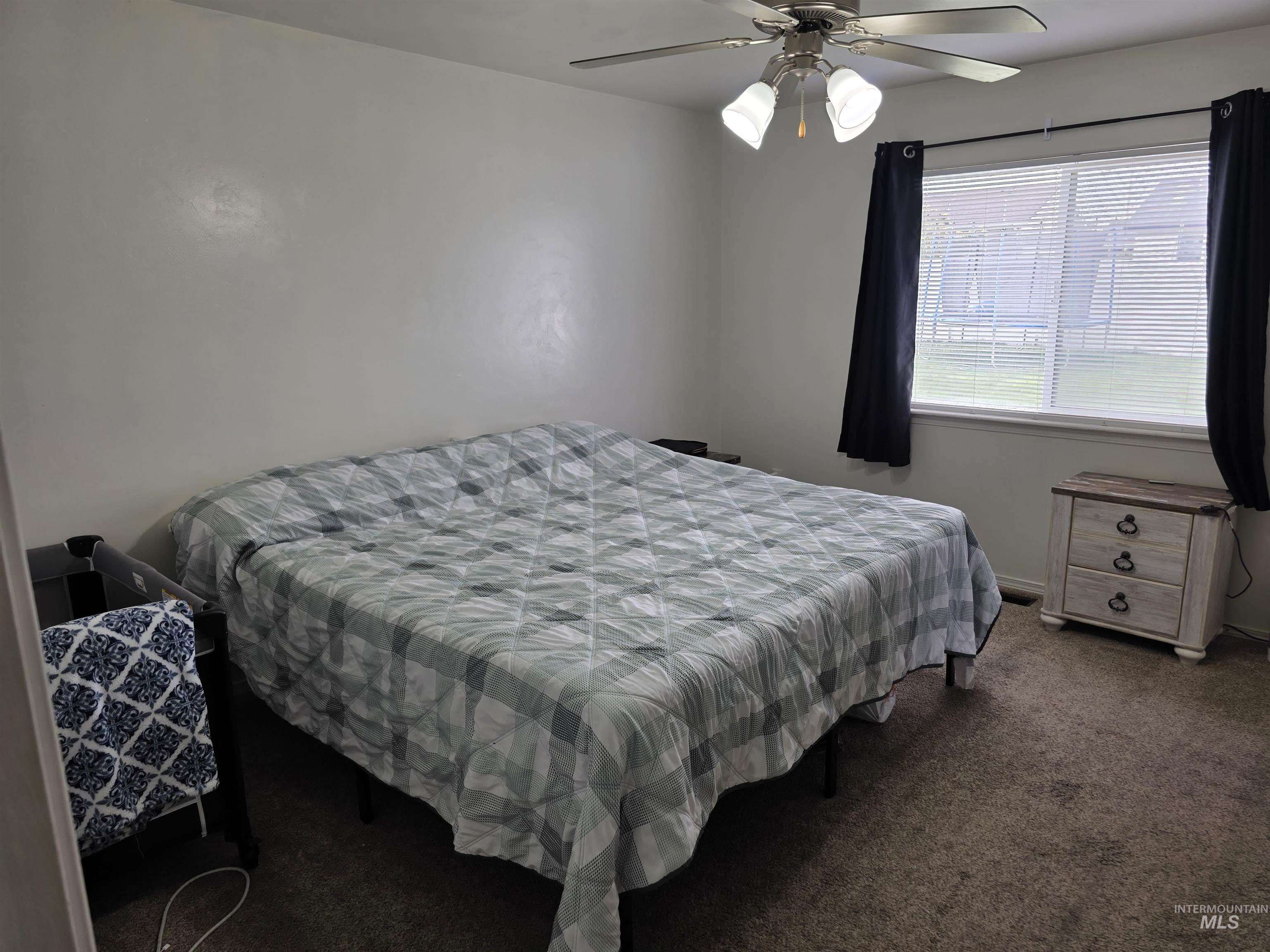 Carpeted bedroom with ceiling fan