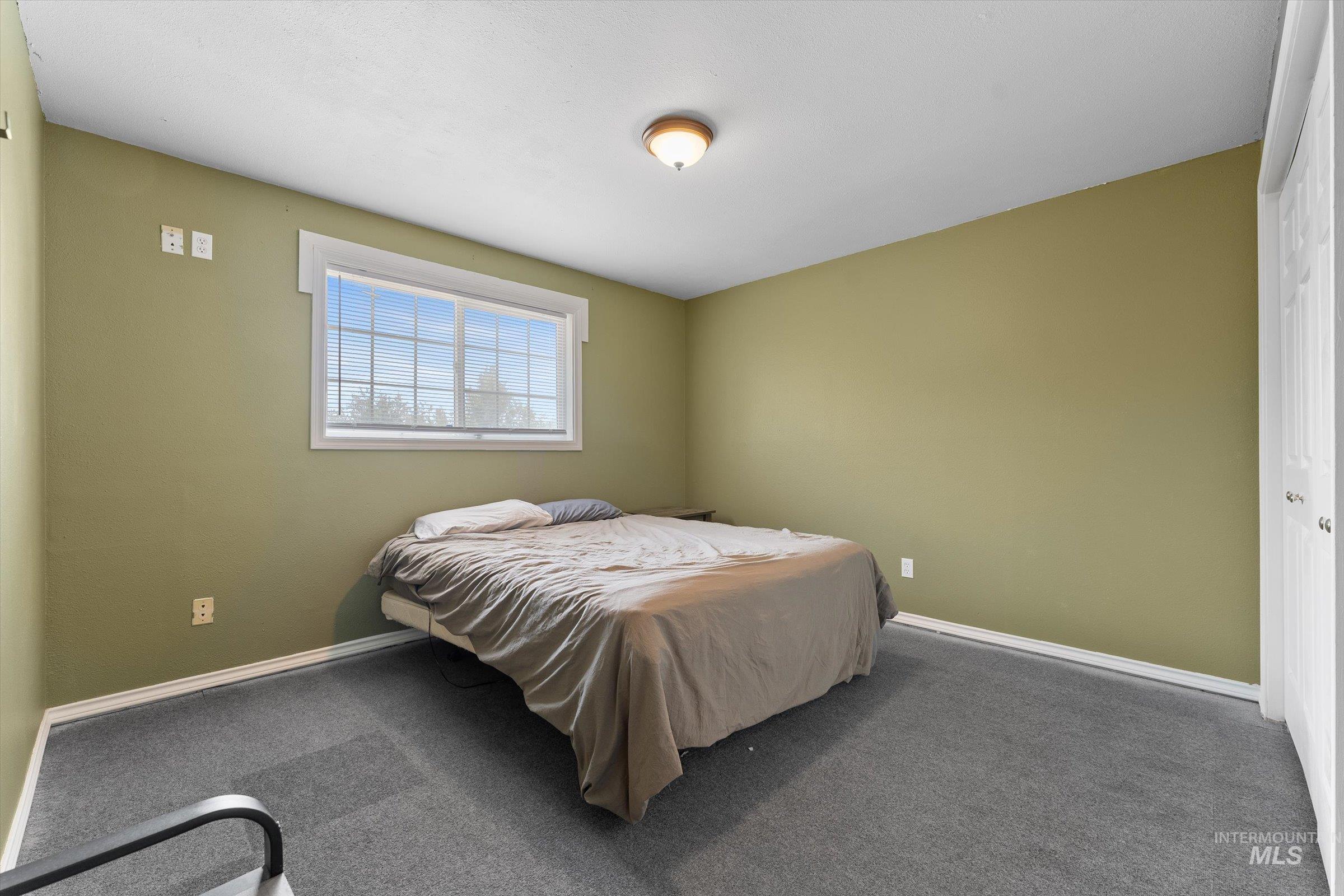 Carpeted bedroom featuring baseboards and a closet