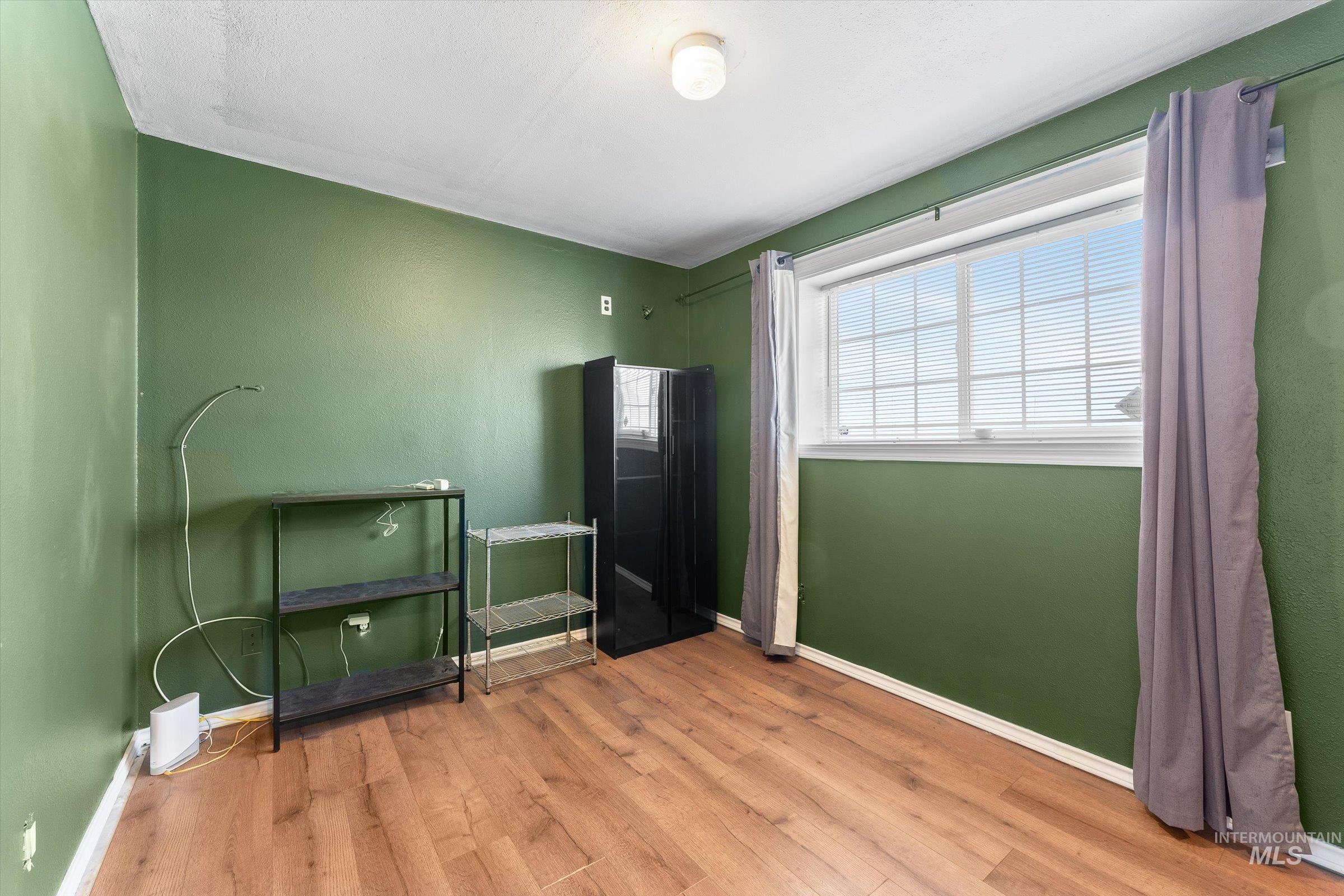 Bedroom featuring light wood-style floors and baseboards