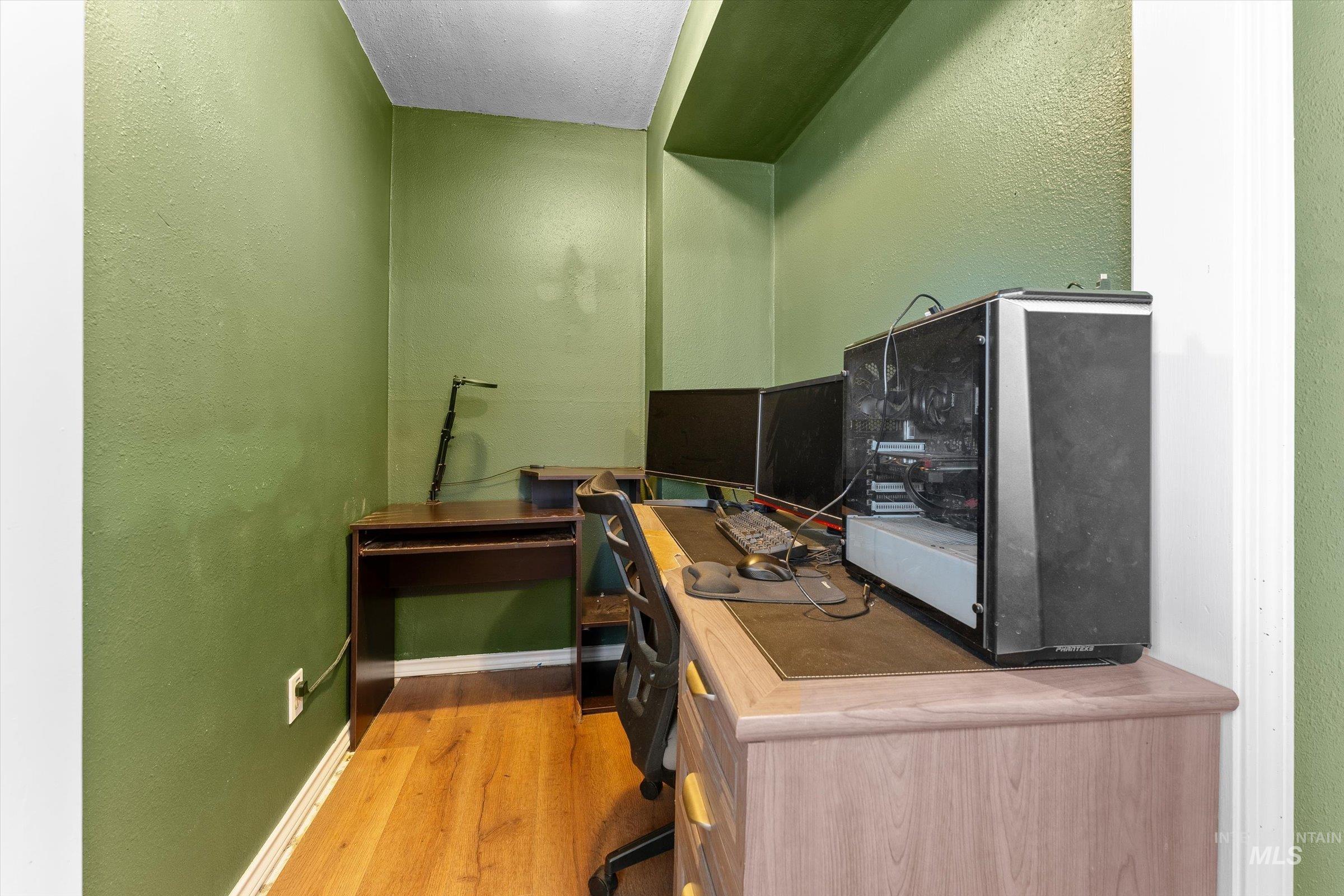 Office area featuring a textured wall and light wood finished floors