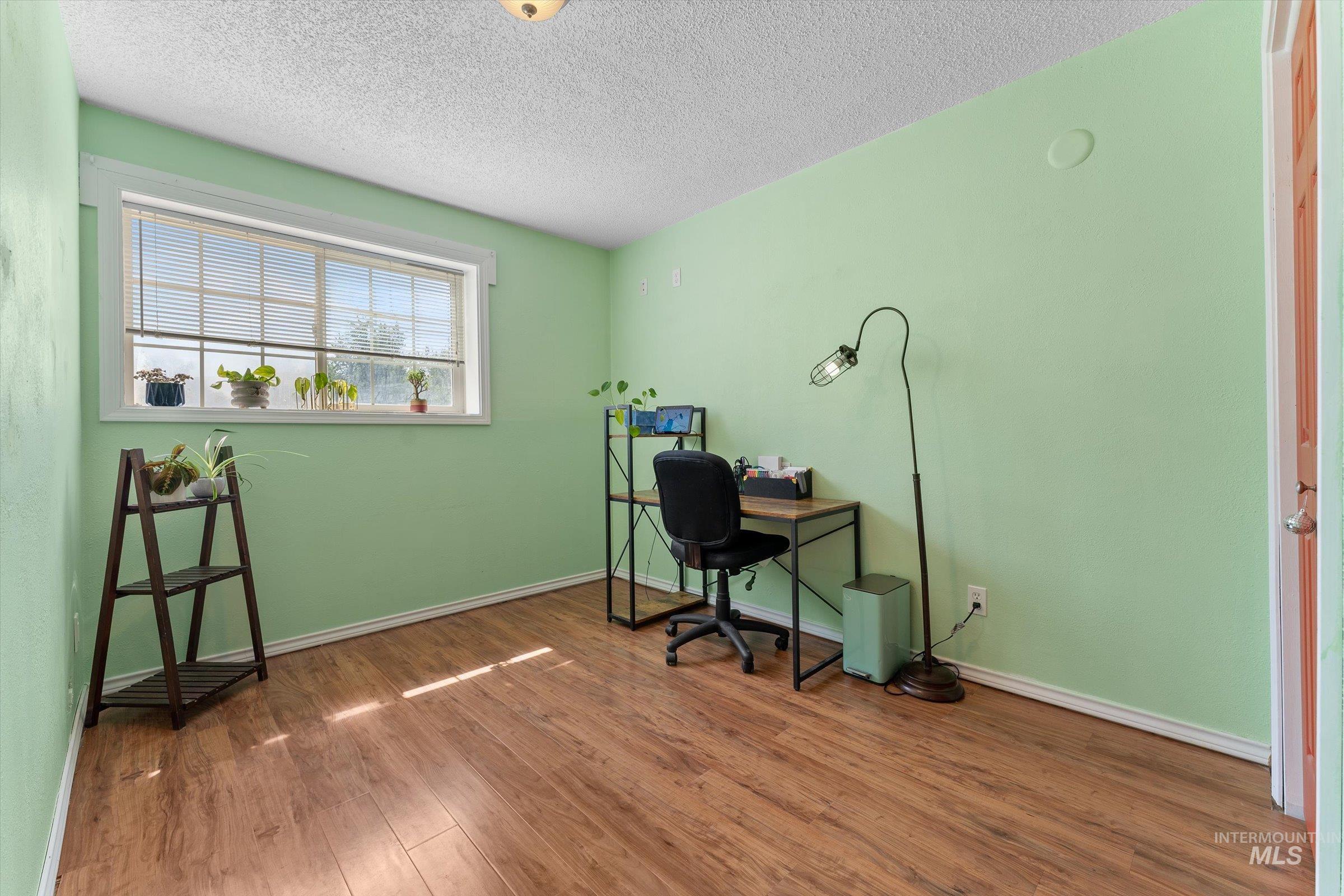 Home office featuring wood finished floors and a textured ceiling