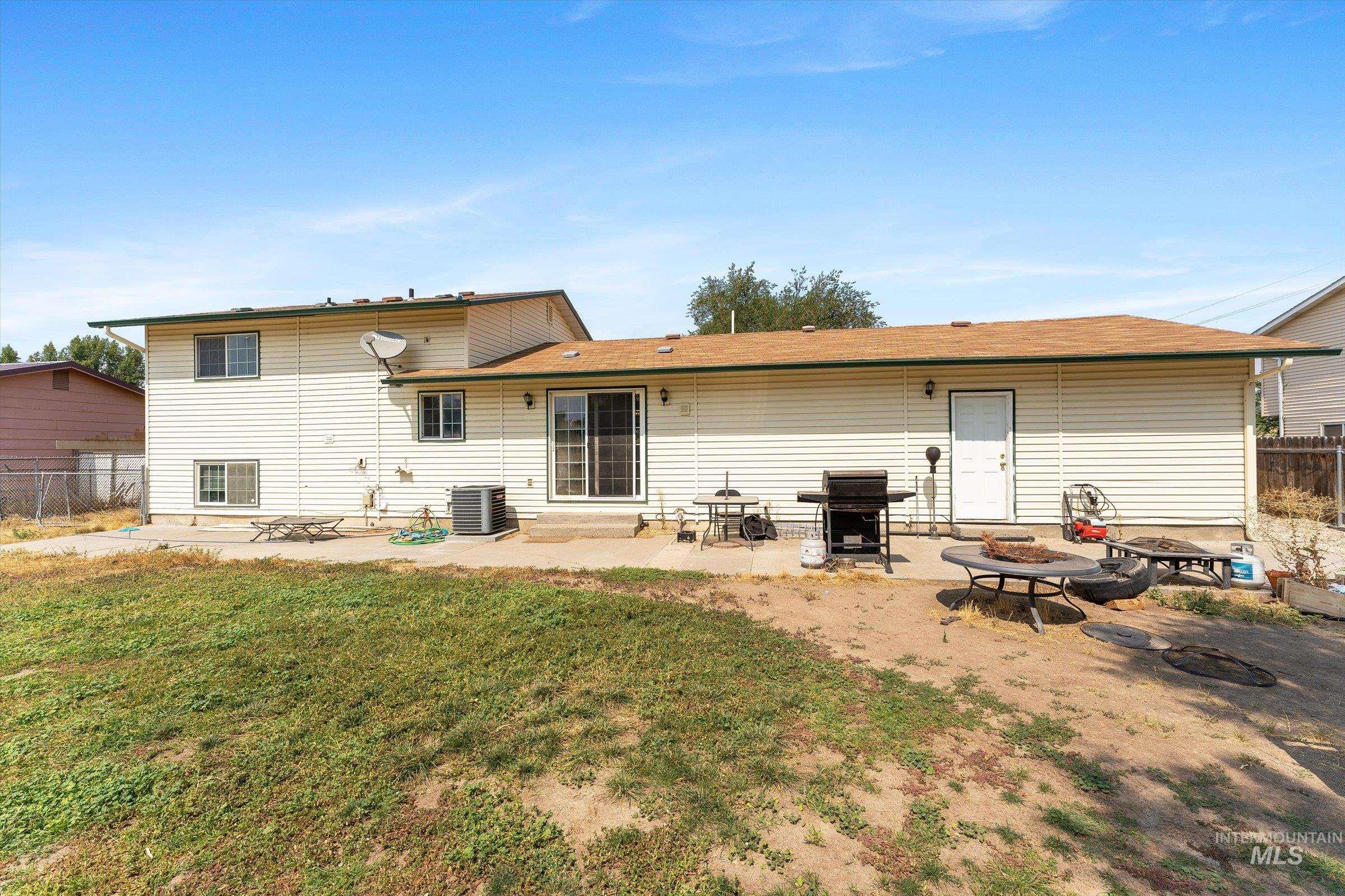 Back of property with a patio area and an outdoor fire pit