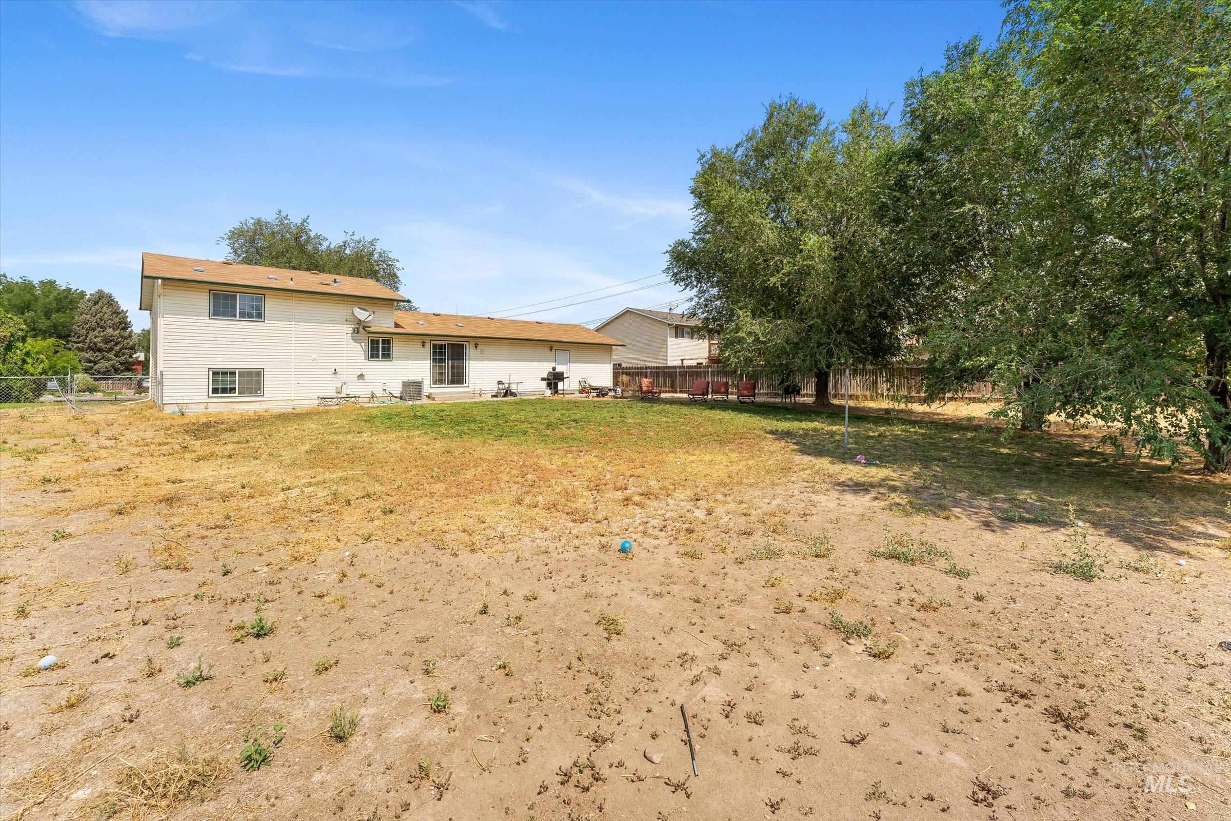 Back of property featuring a fenced backyard and a patio