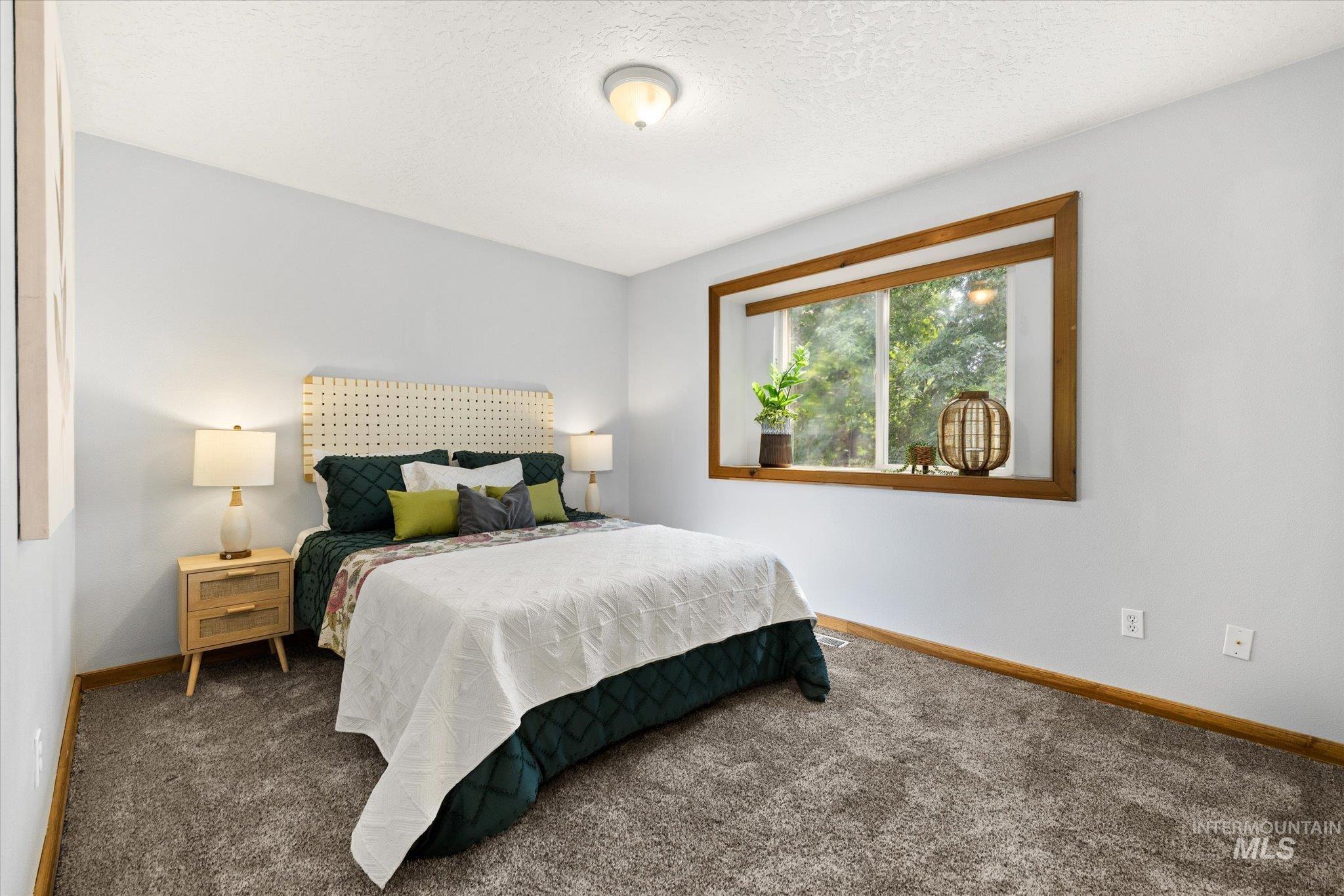 Bedroom with carpet flooring and a textured ceiling