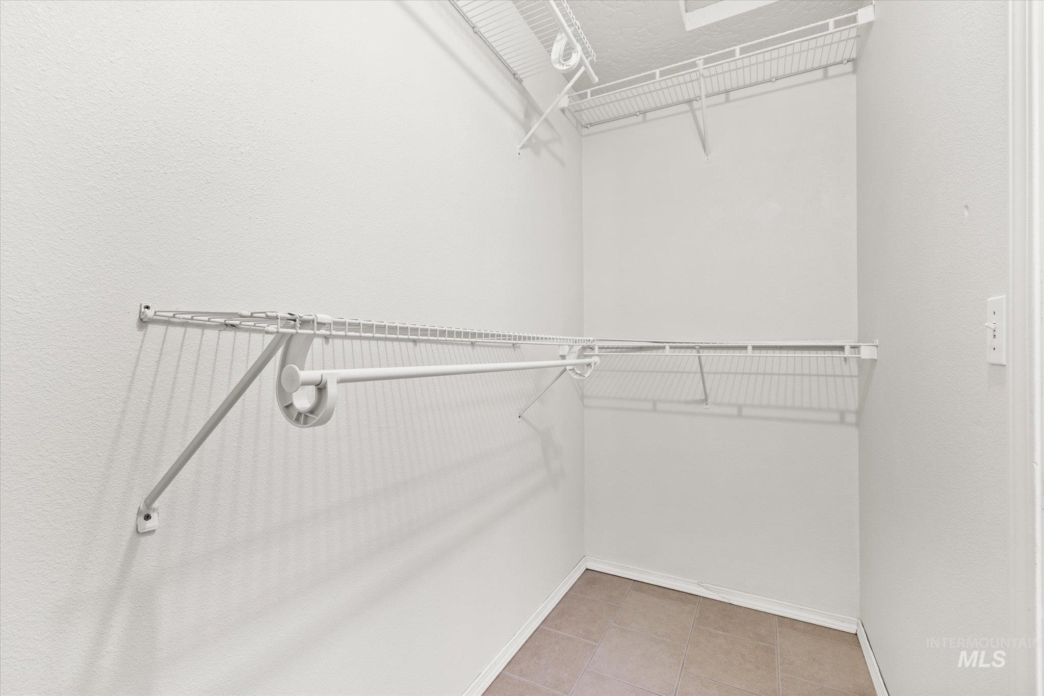 Walk in closet with light tile patterned floors