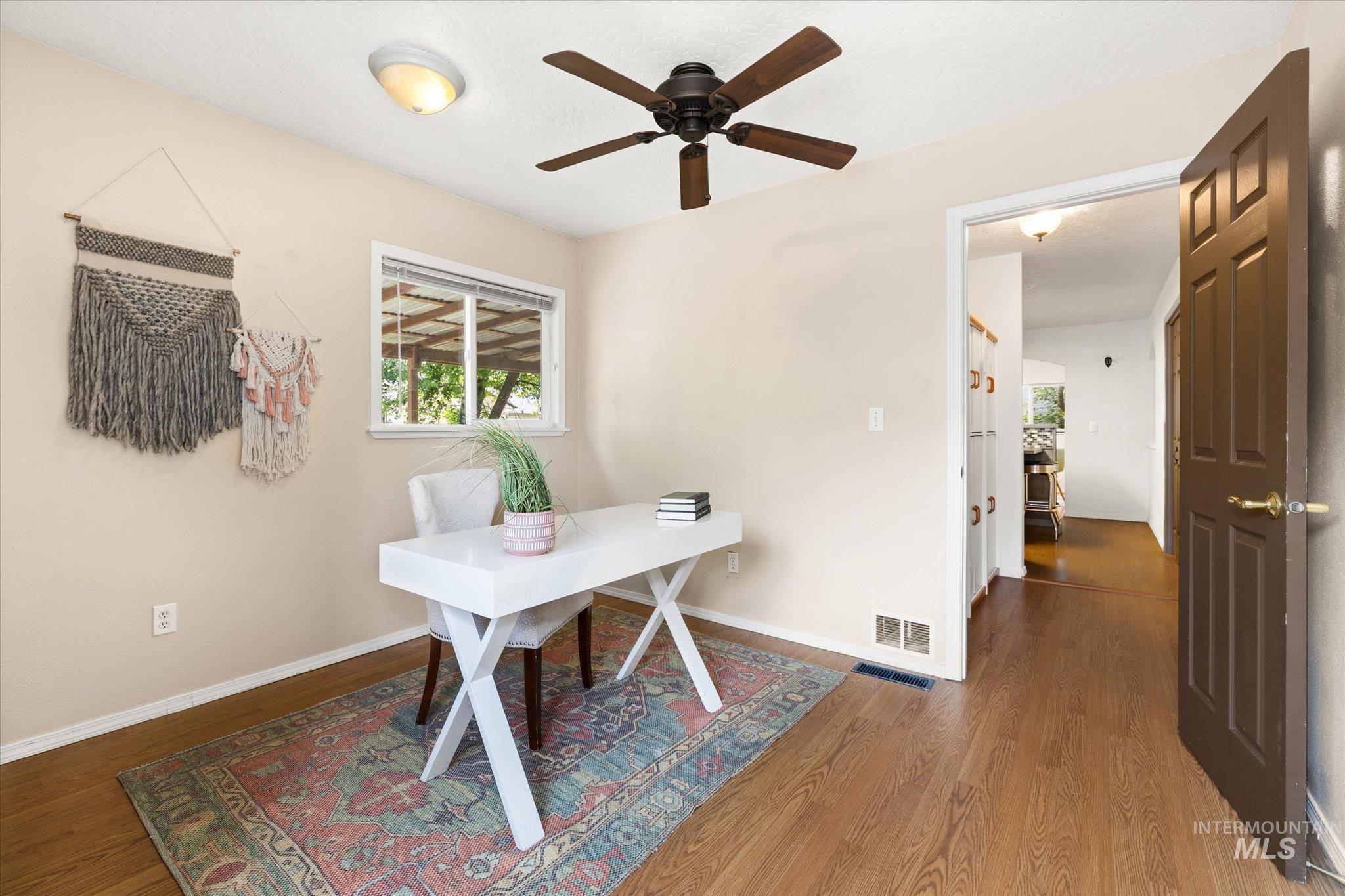 Home office featuring dark wood finished floors and a ceiling fan