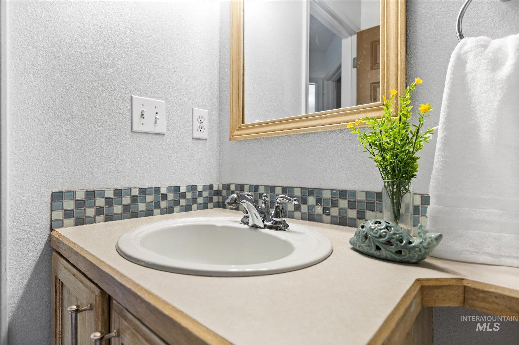 Bathroom with a textured wall and vanity