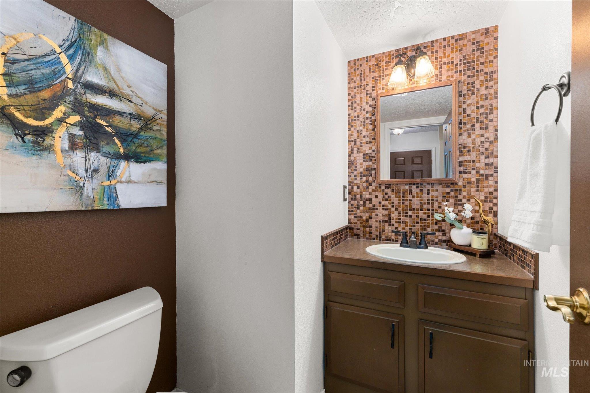 Bathroom with vanity, backsplash, and a textured ceiling
