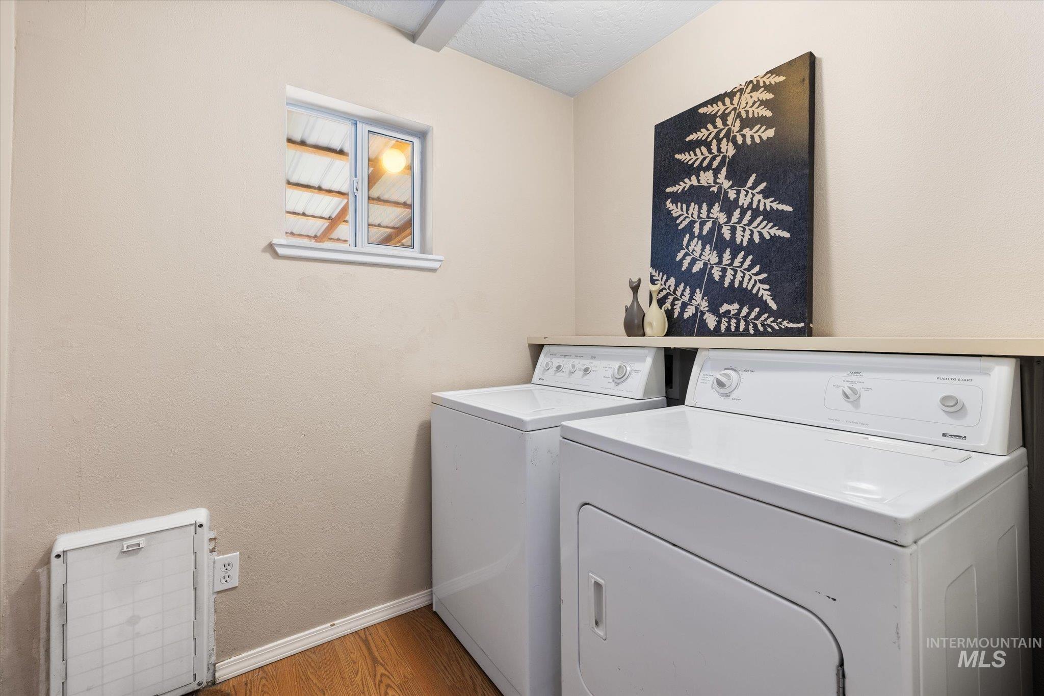 Laundry area with light wood finished floors and independent washer and dryer