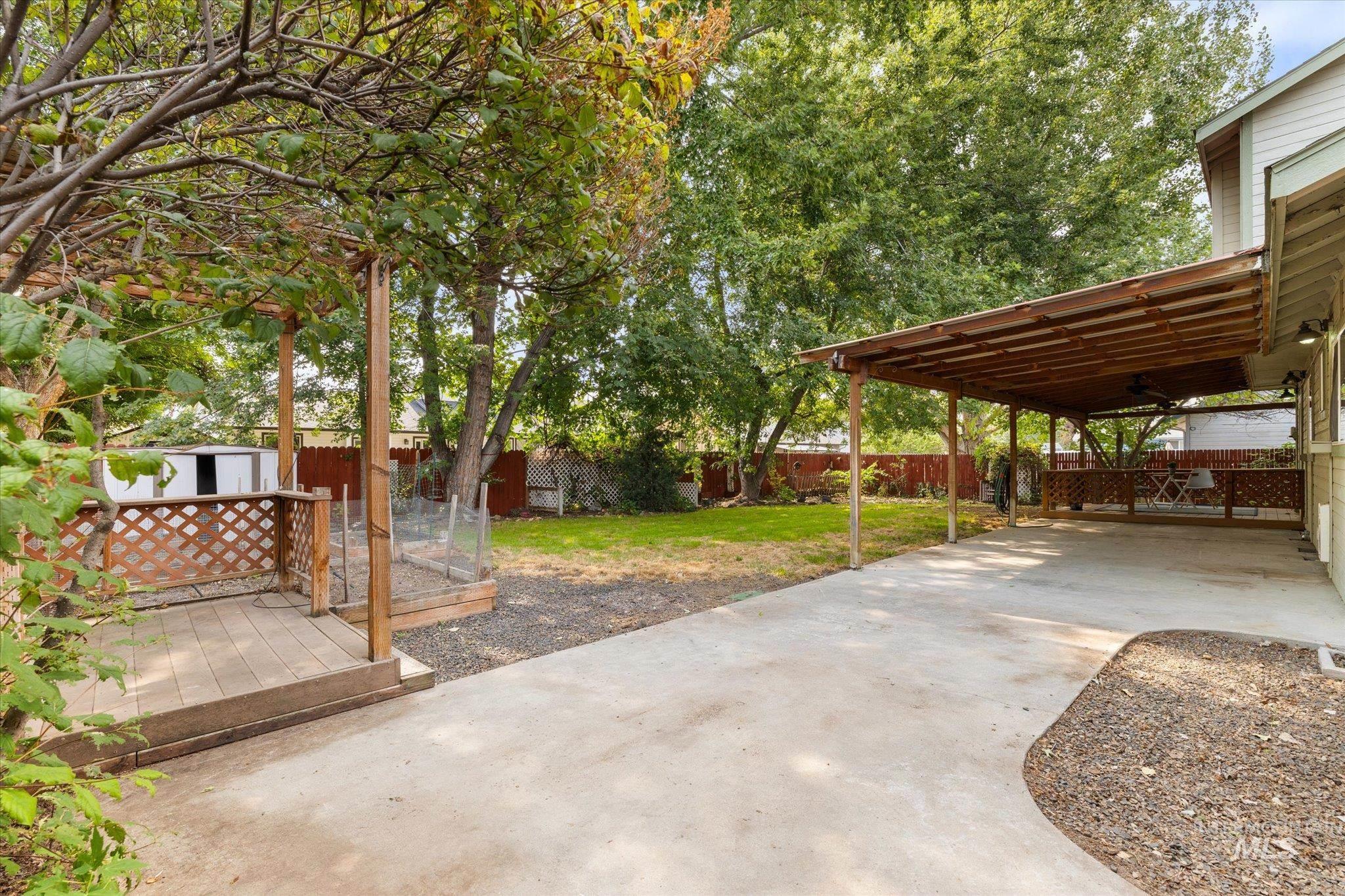 Fenced backyard featuring a deck and a shed