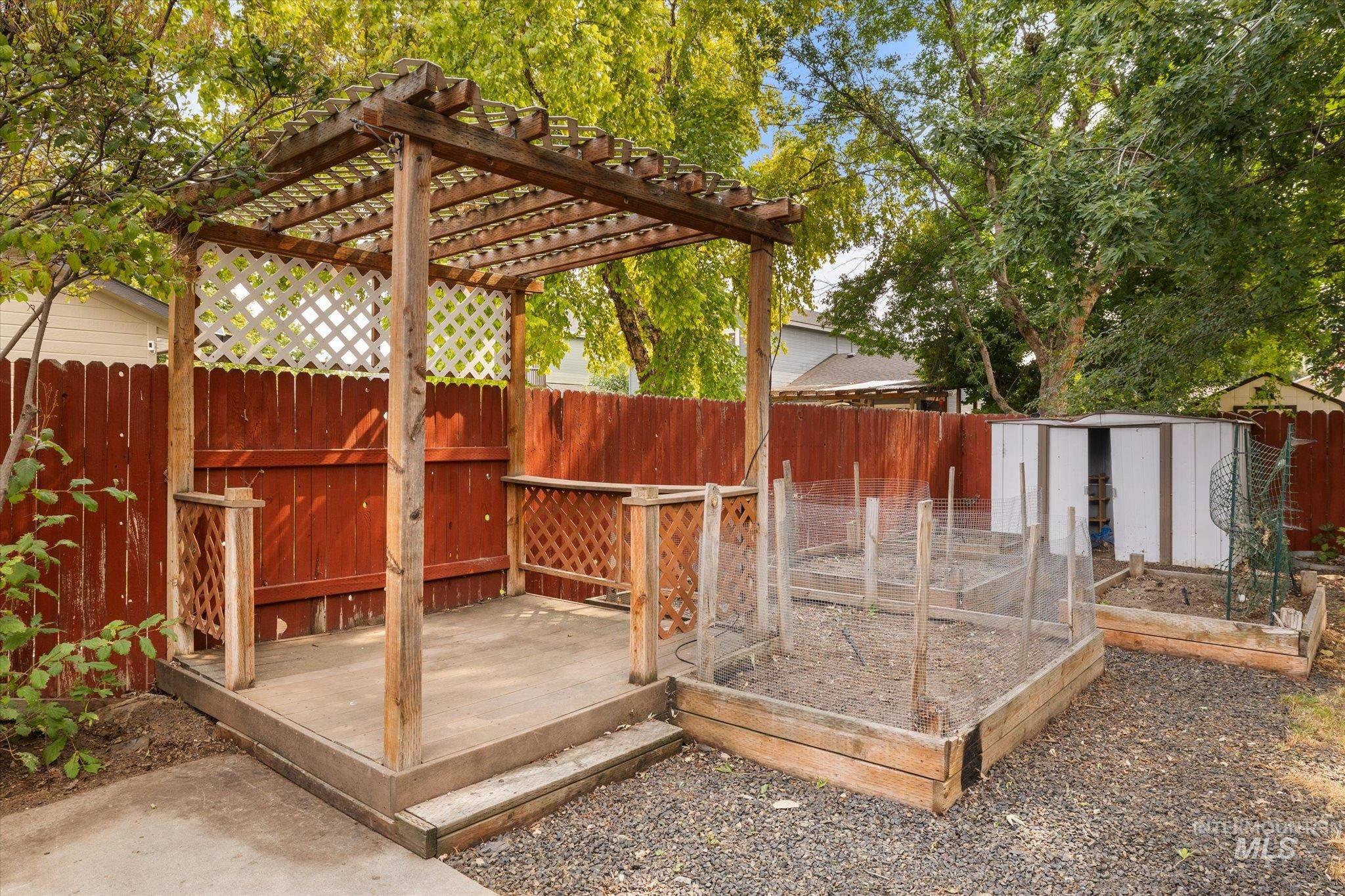 Deck with a fenced backyard, a shed, and exterior structure