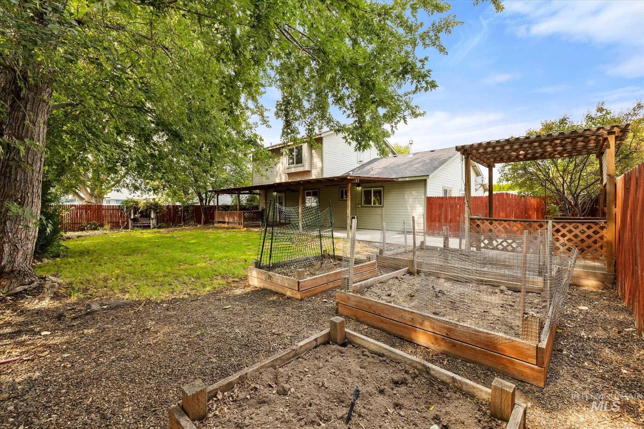 Fenced backyard with a wooden deck and a garden