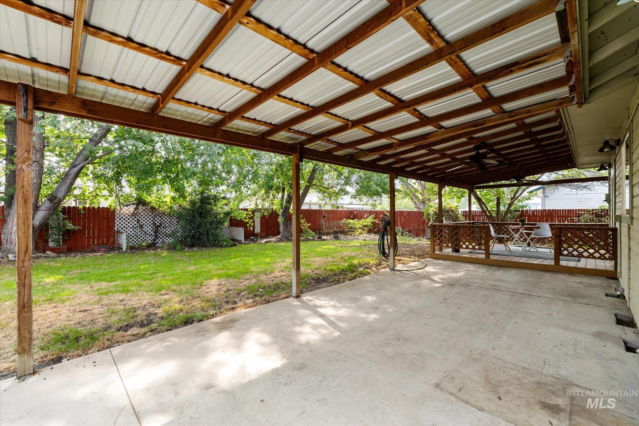 Fenced backyard with a patio and a ceiling fan