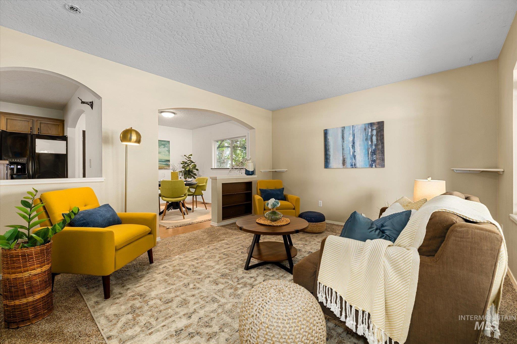 Living area featuring a textured ceiling and arched walkways