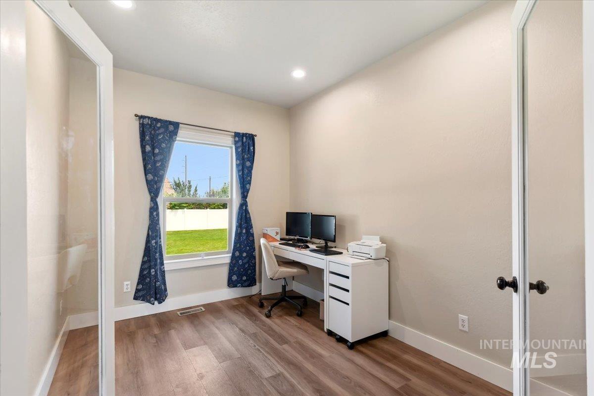 Office area with wood finished floors and recessed lighting