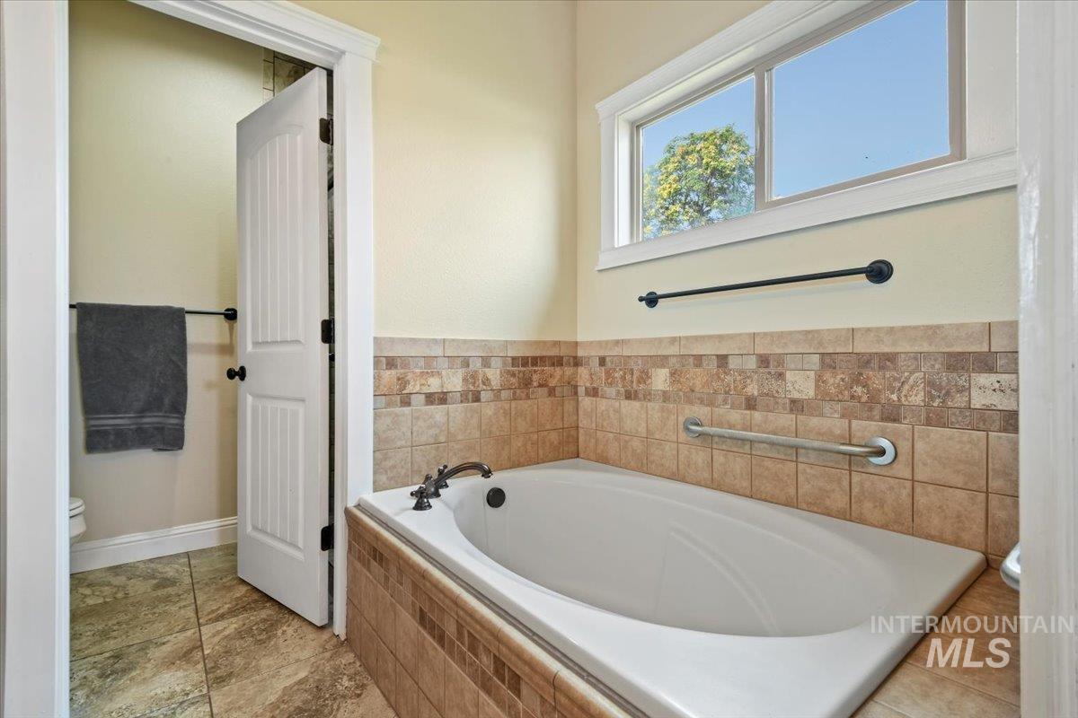 Bathroom with a garden tub and toilet