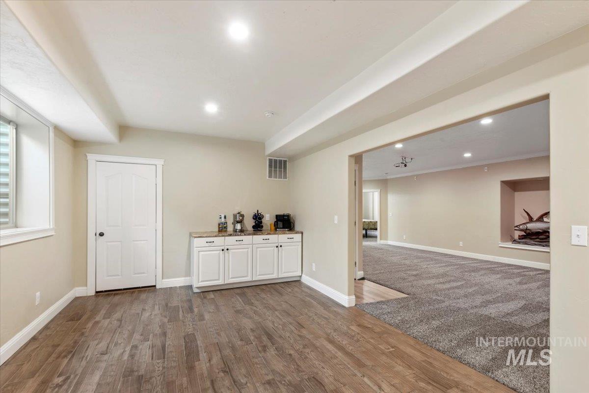 Bar area featuring recessed lighting, dark wood-style floors, white cabinetry, and dark colored carpet